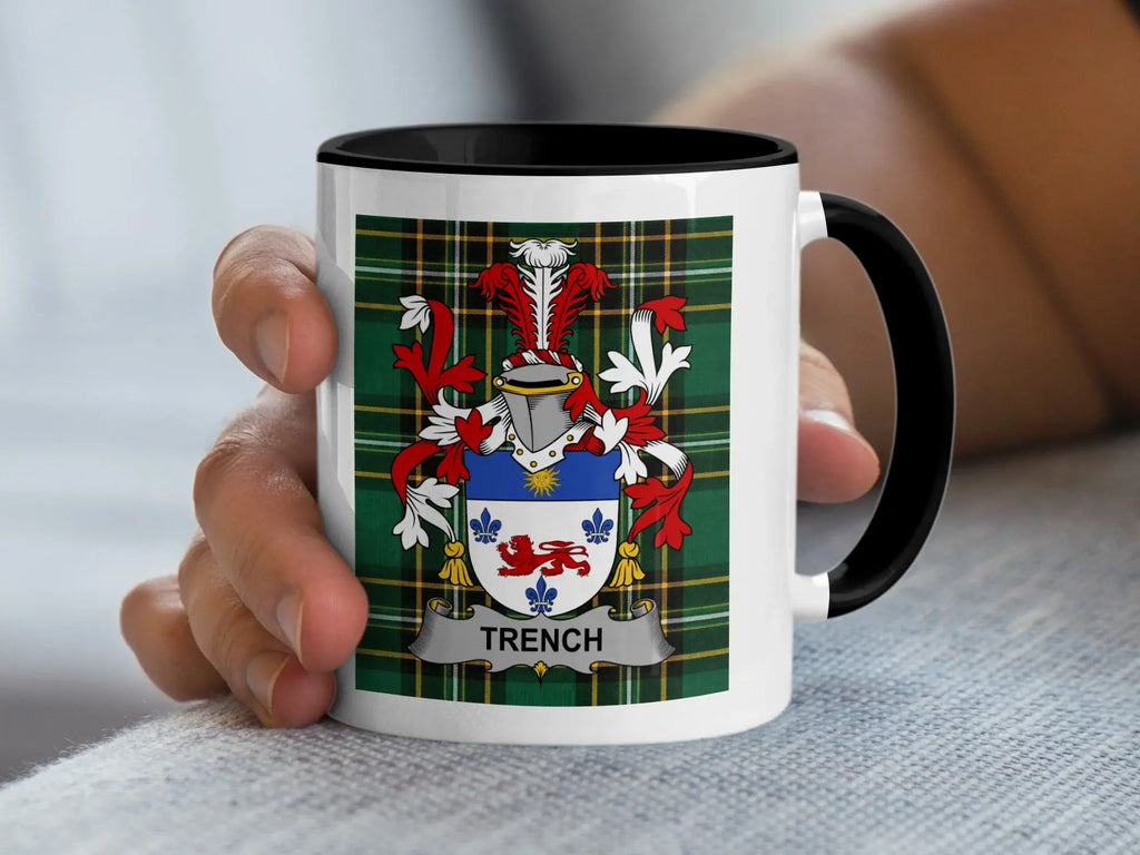 Mug with Trench family crest and plaid pattern held by a hand.