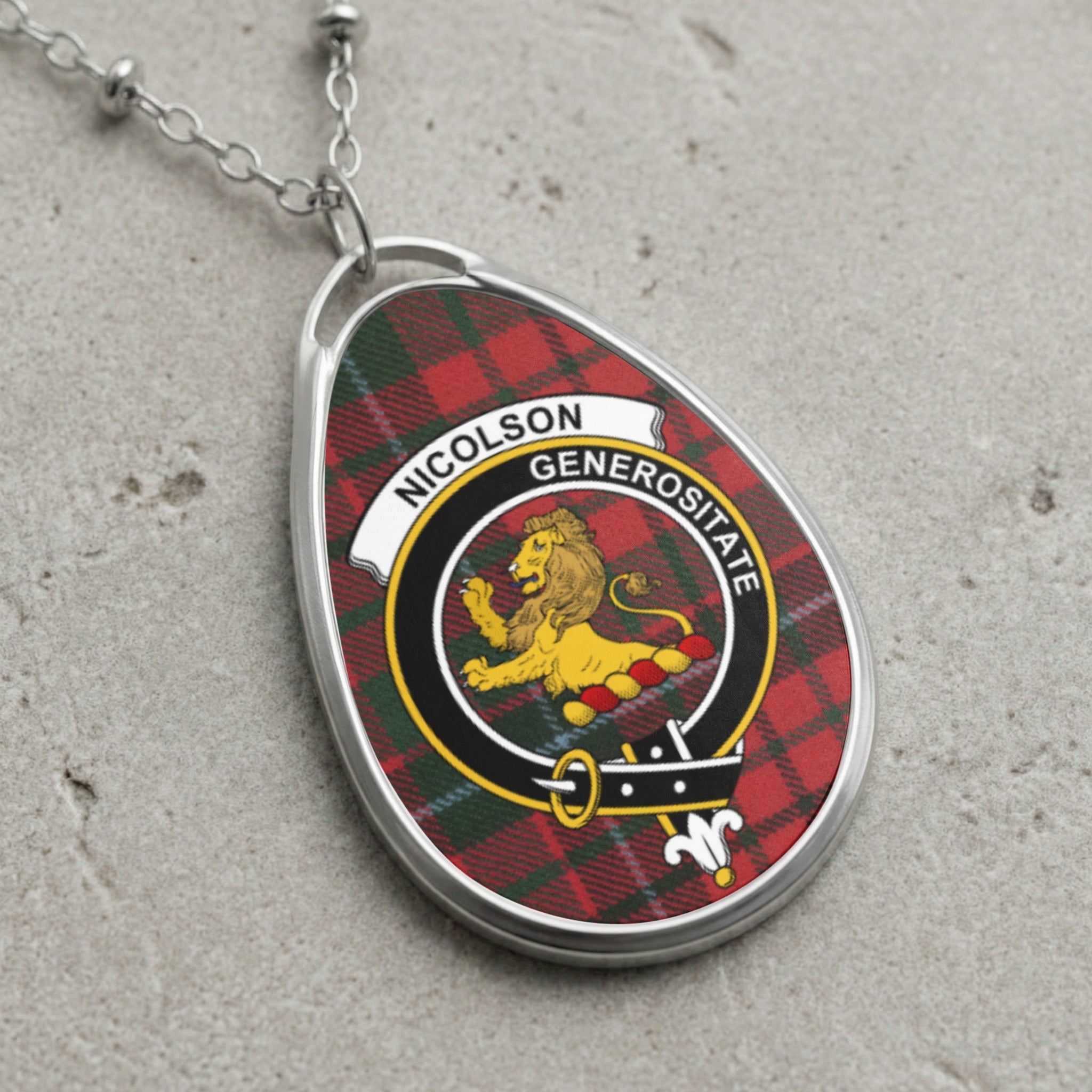 Oval pendant with Nicolson clan crest on red tartan and silver chain.