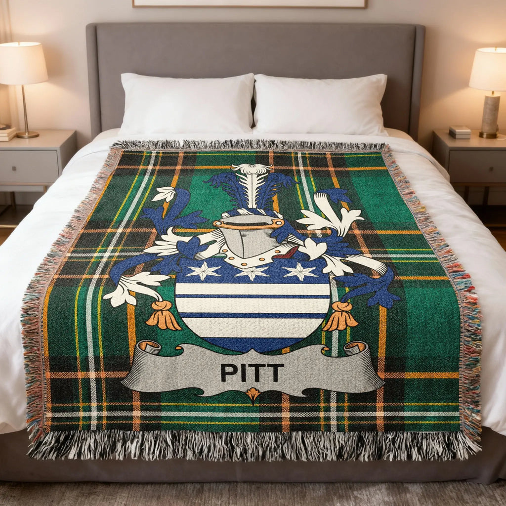 Tartan blanket with Pitt family crest displayed on a bed.