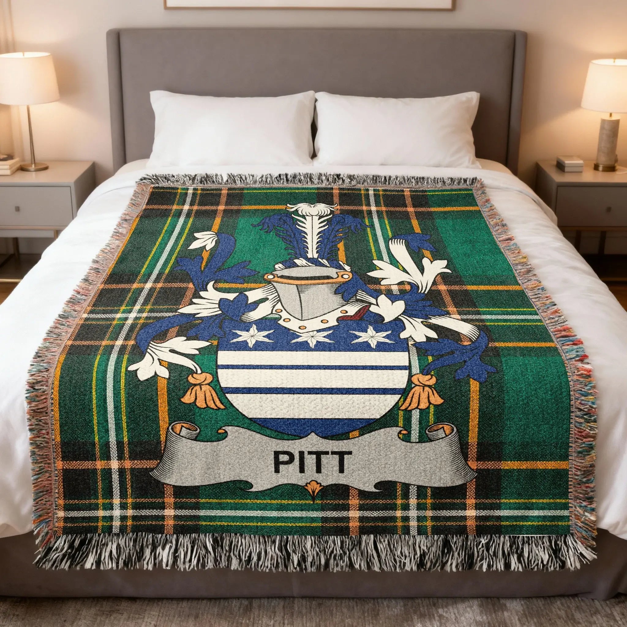 Tartan blanket with Pitt family crest displayed on a bed.