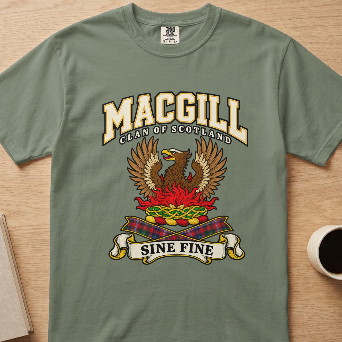 MacGill clan T-shirt in sage green, front view with brown bird with raised wings above red flames