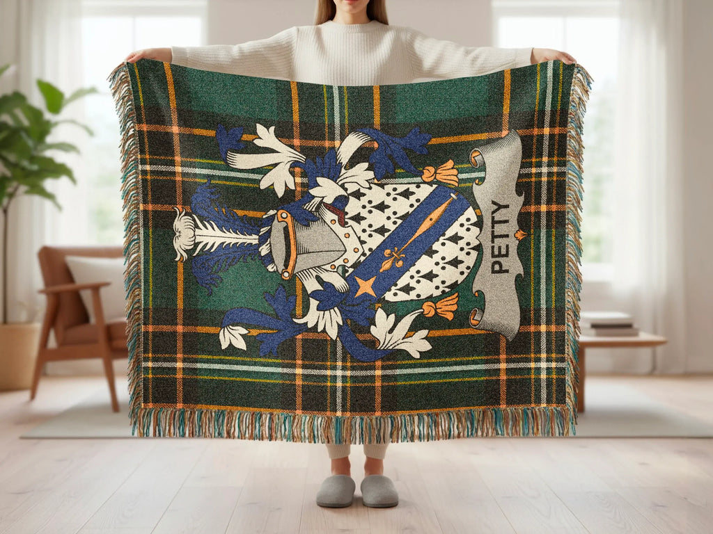 Tartan plaid blanket with crest and "PETTY" text, held up by a person.