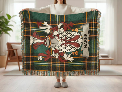 Tartan blanket with a crest and HARNE text, held by a person.
