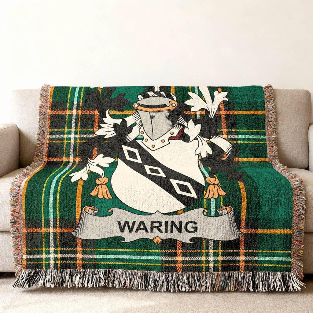 Waring family crest on a green and black plaid throw blanket on a sofa.
