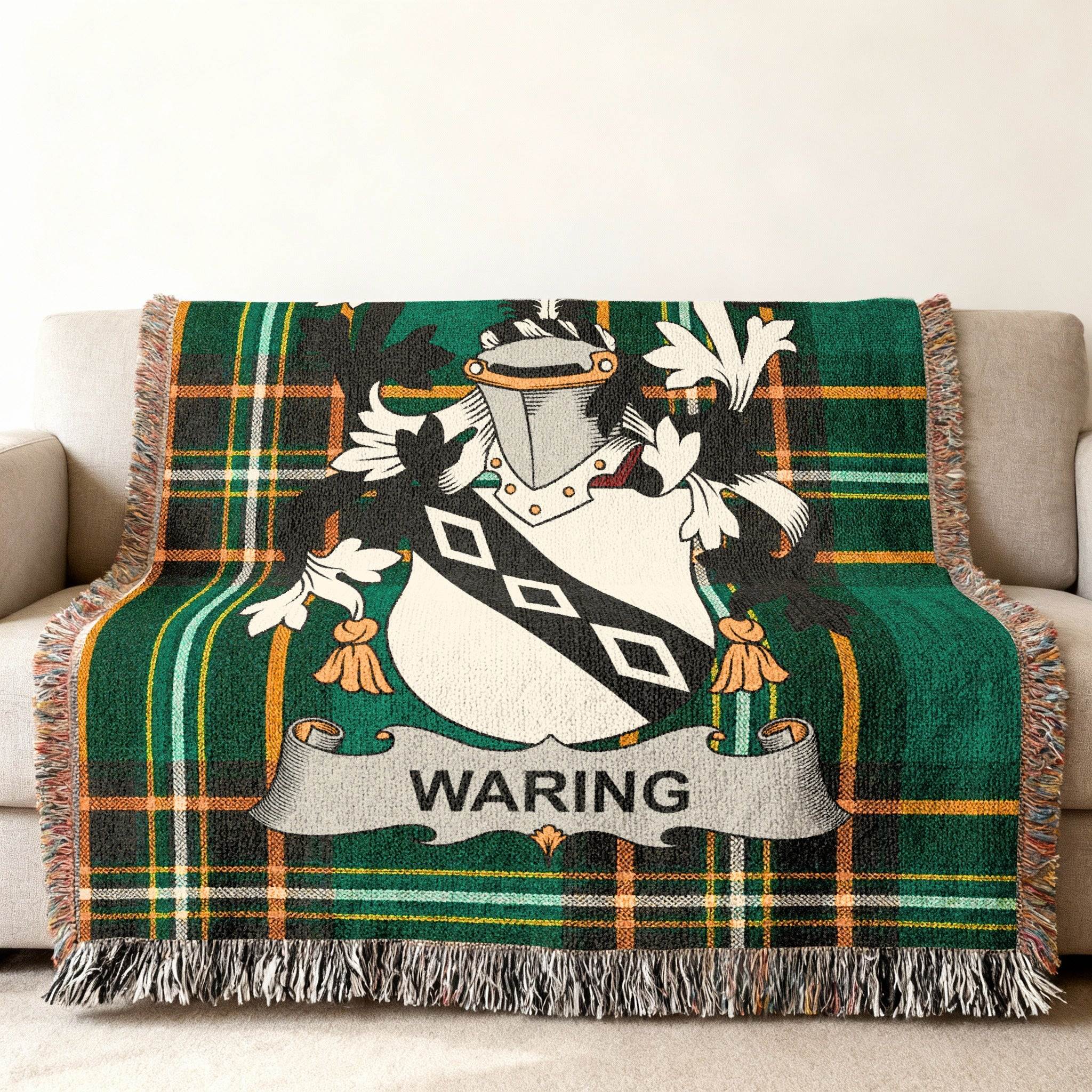Waring family crest on a green and black plaid throw blanket on a sofa.