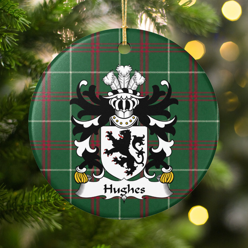 Hughes Style 2 ornament hanging among Christmas tree branches and warm lights; a black lion on a white shield on Welsh national tartan.