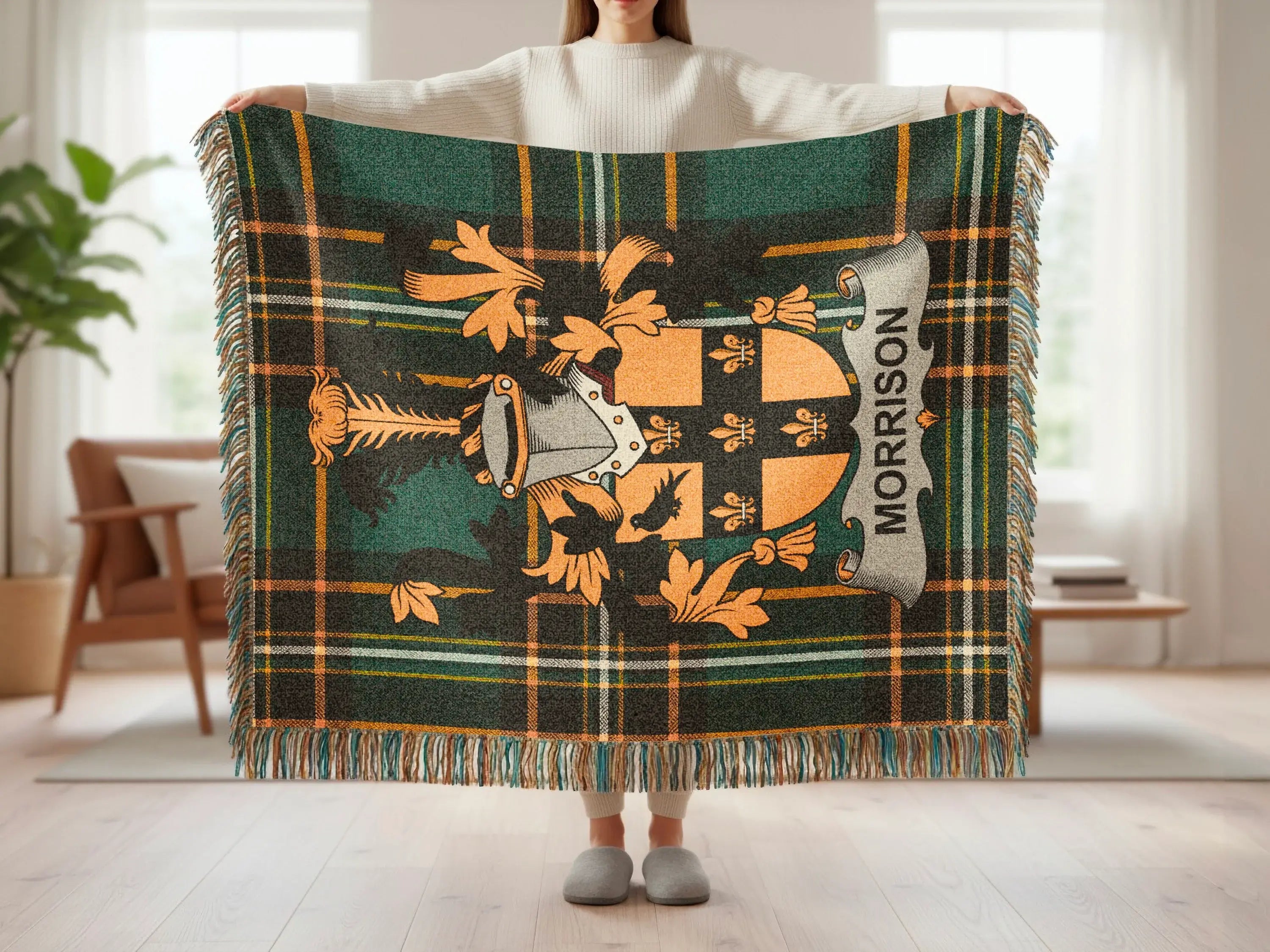 Tartan plaid throw blanket with Morrison clan crest, held by a person.