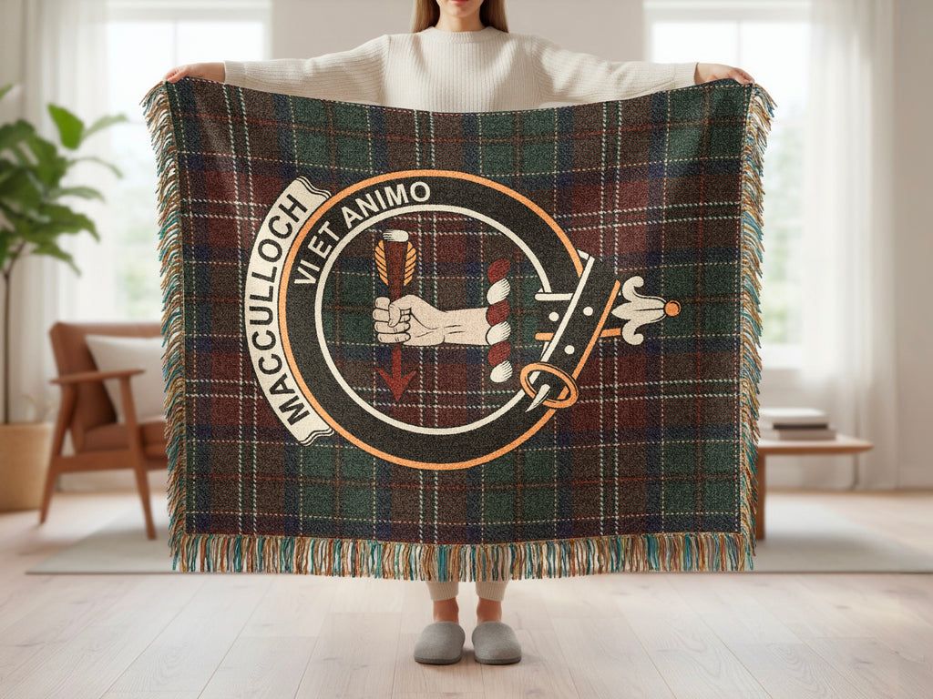 Person holding the MacCulloch woven blanket to show the full design, tartan background and fringe