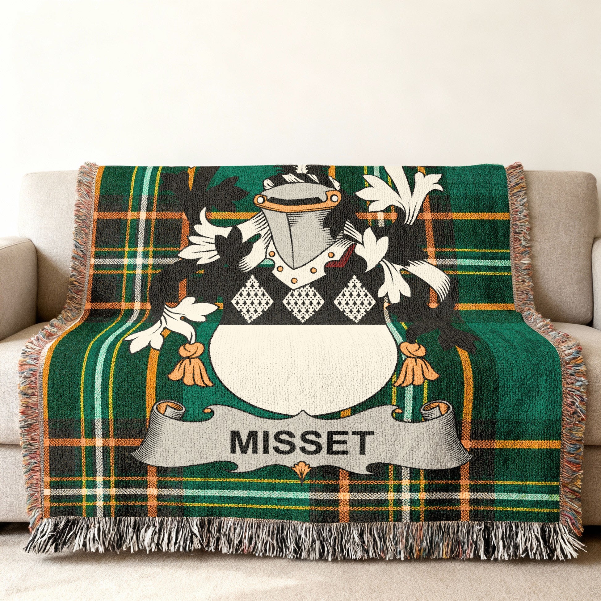 Green tartan blanket with Misset family crest on a sofa.