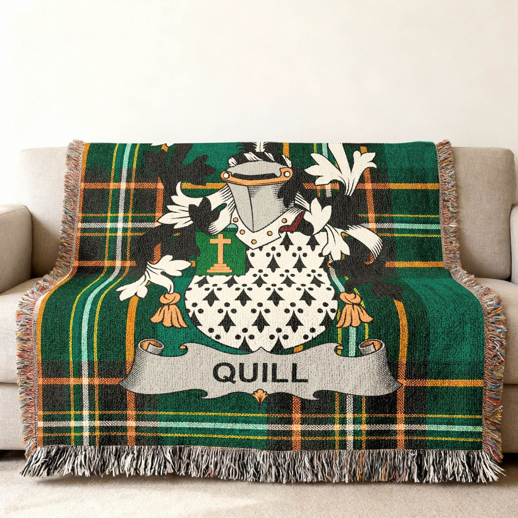 Green tartan blanket with Quill family crest on a couch.