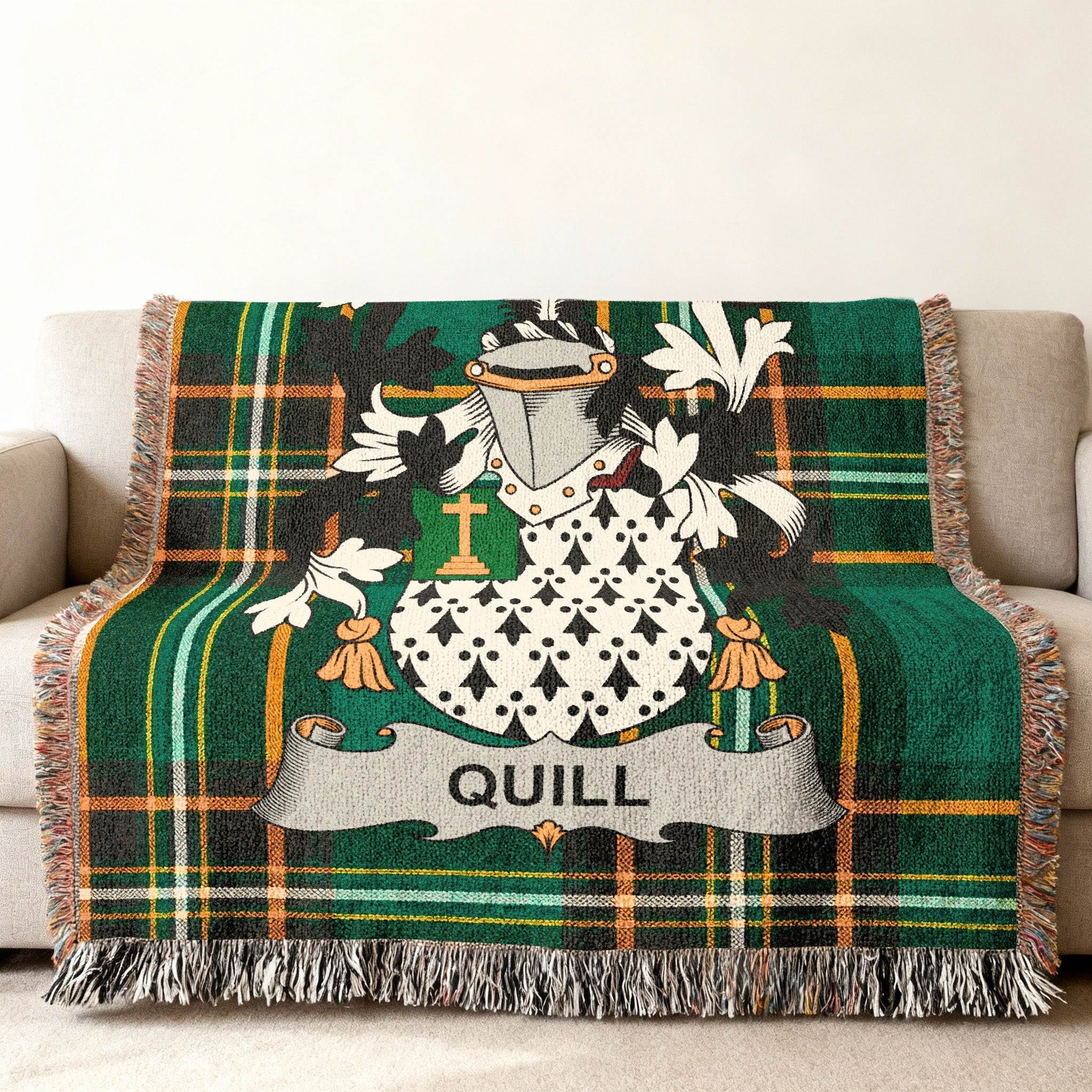 Green tartan blanket with Quill family crest on a couch.