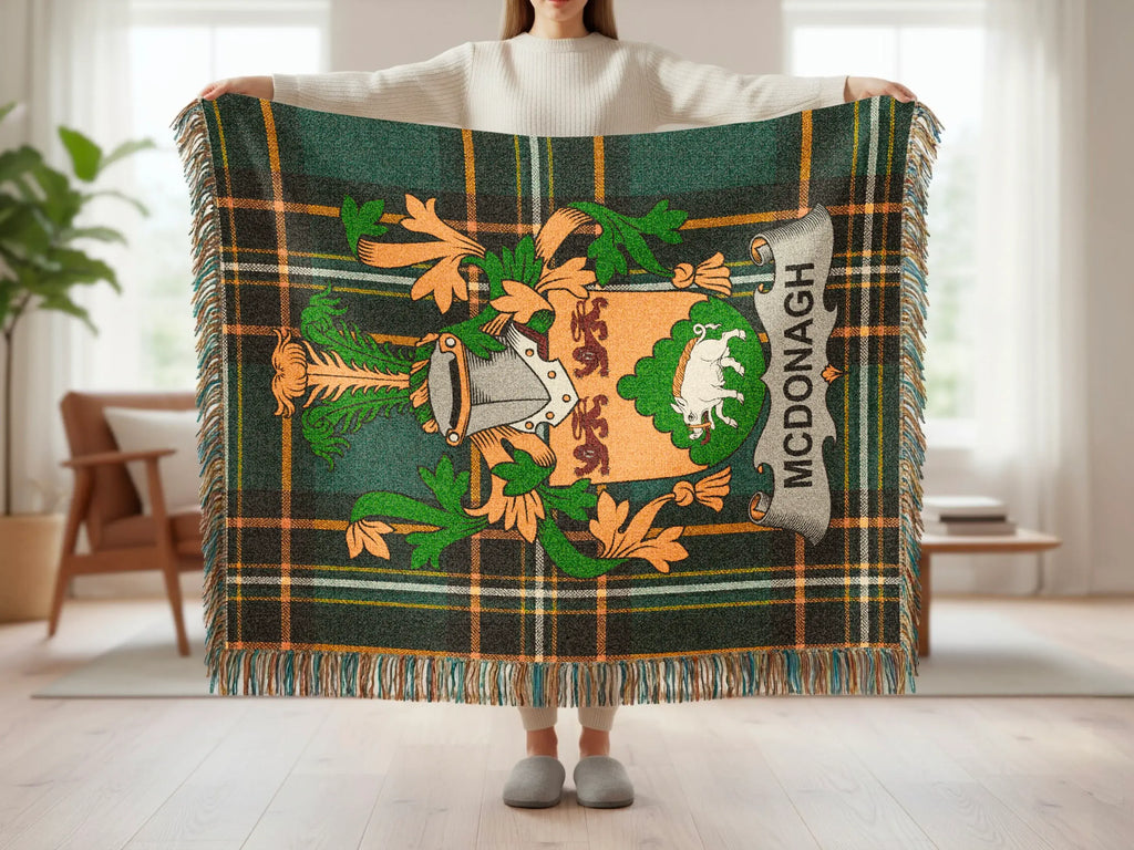 McDonagh tartan blanket with crest featuring a boar, held by person.