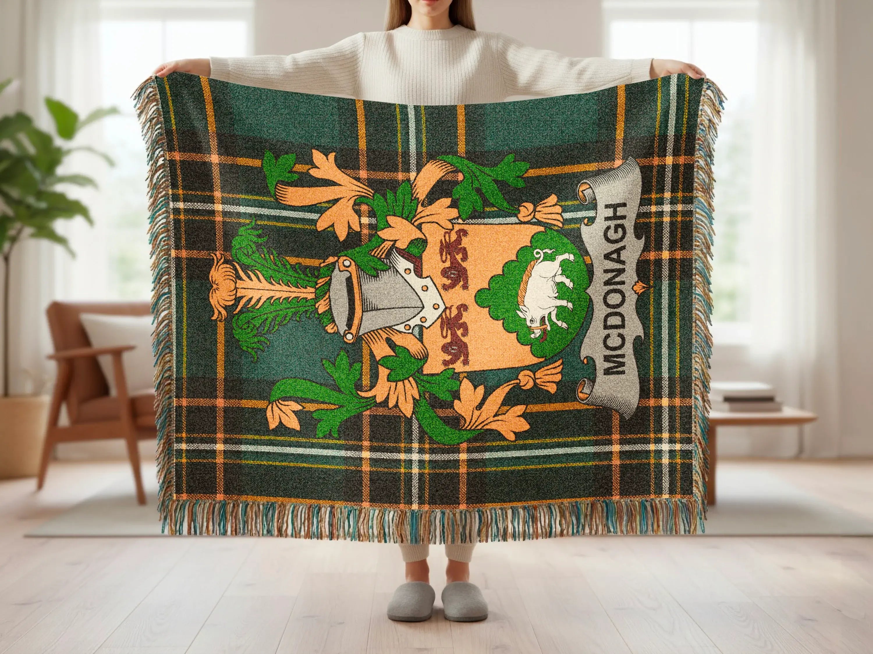 McDonagh tartan blanket with crest featuring a boar, held by person.