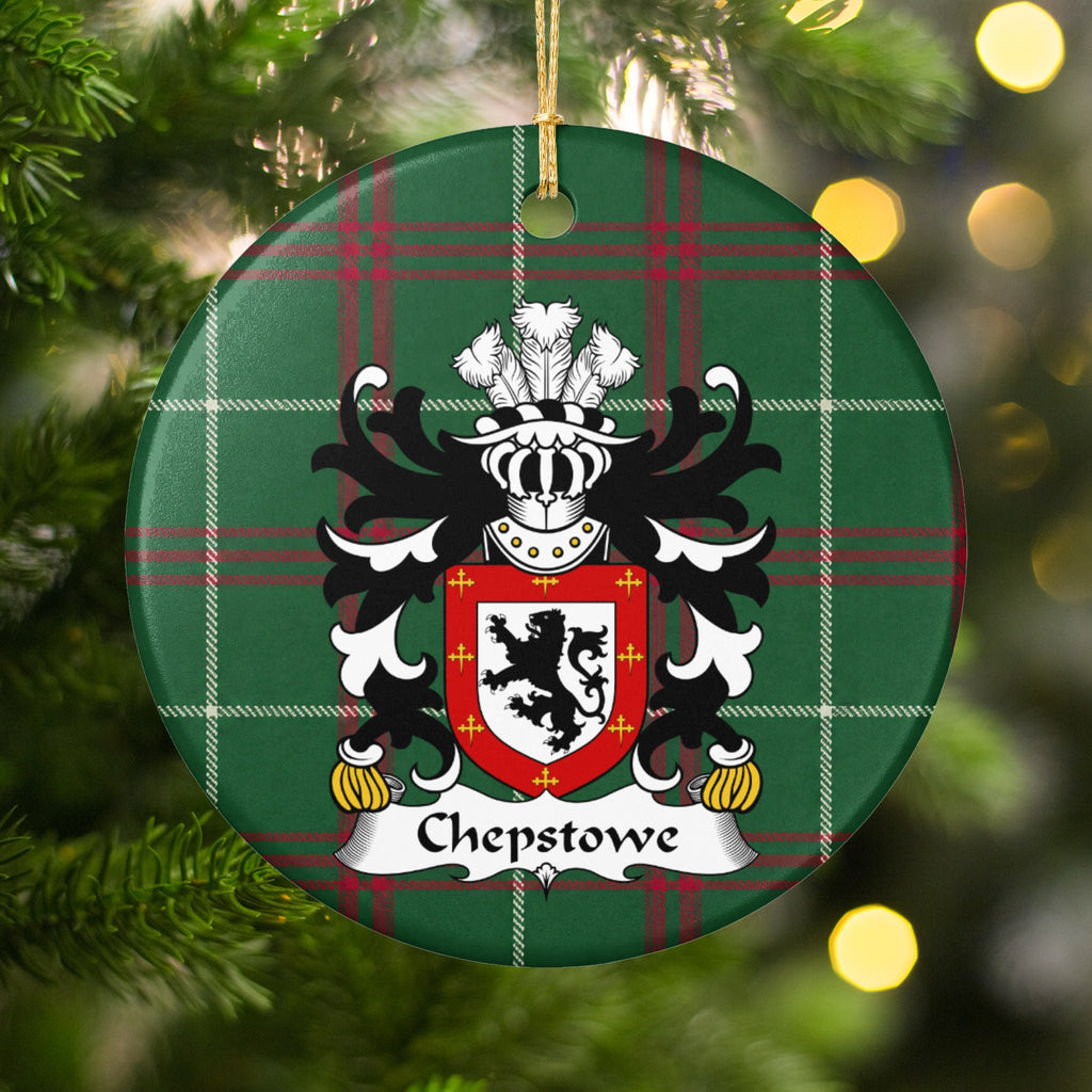 Chepstowe ornament hanging among Christmas tree branches and warm lights; a black upright lion on white within a red border decorated with small gold crosses on Welsh national tartan.