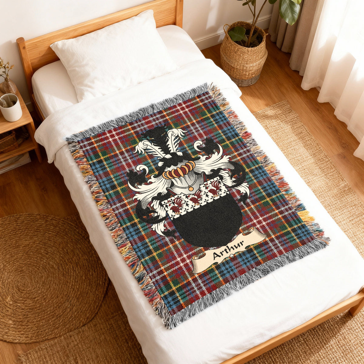 Arthur Scottish family shield woven blanket with Caledonia tartan background, displayed on a bed