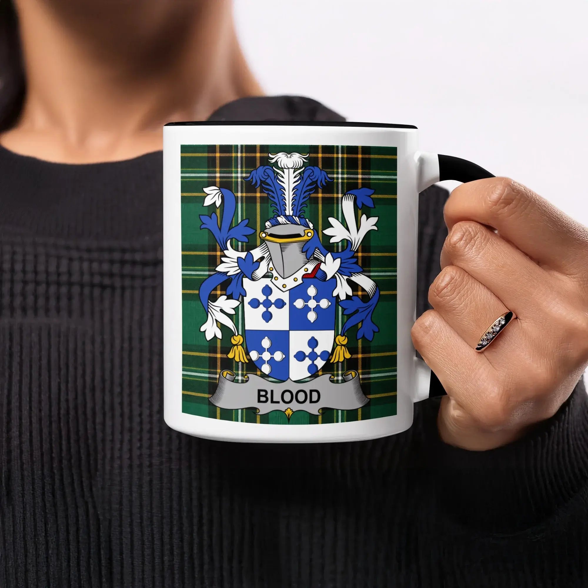 Mug with Blood family crest on green tartan background.