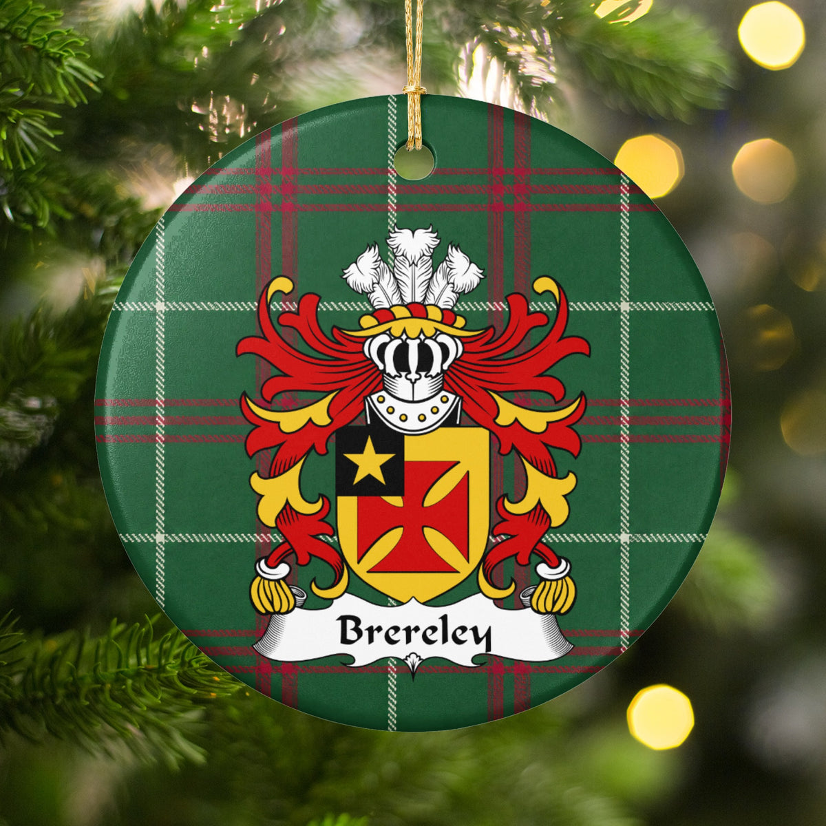 Brereley ornament hanging in a Christmas tree with warm lights; a red flared cross on gold with a gold star in a black corner panel on Welsh national tartan.