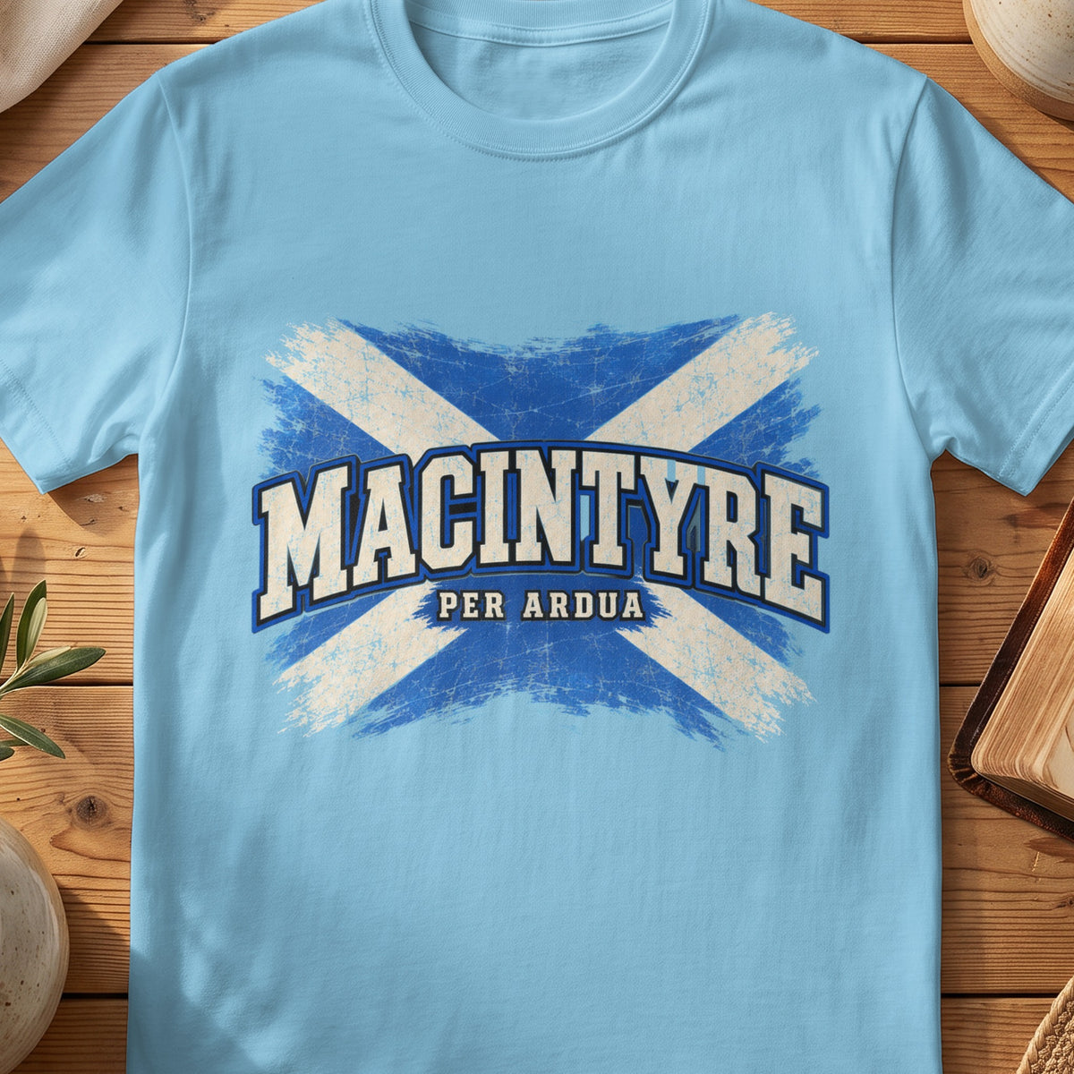 MacIntyre Scottish Saltire T-shirt in Sky, with distressed blue and cream flag and “Per Ardua” lettering.