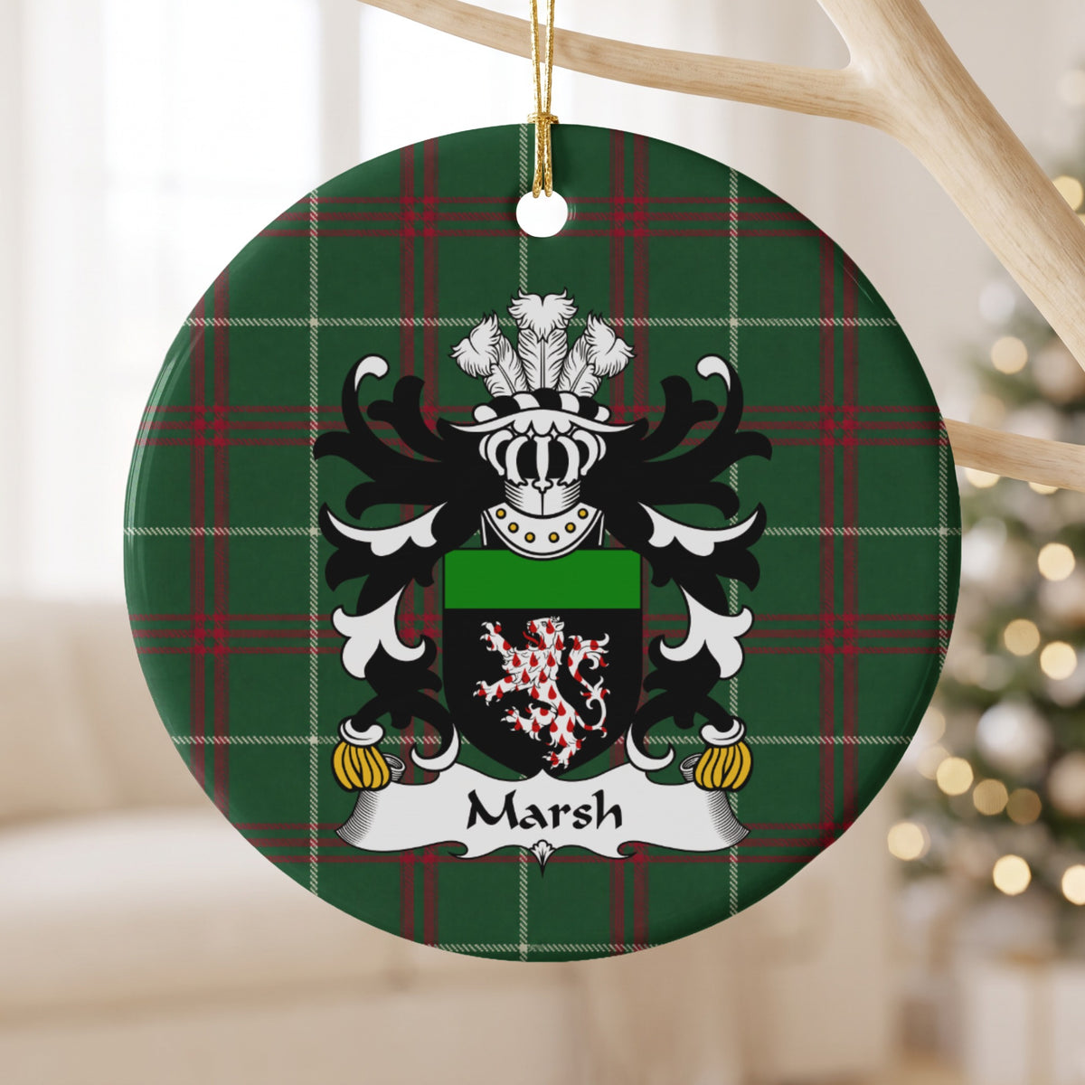 Marsh ornament hanging from a pale wooden branch, showing a red-and-white patterned lion on a black shield with a green top band on Welsh National Tartan.