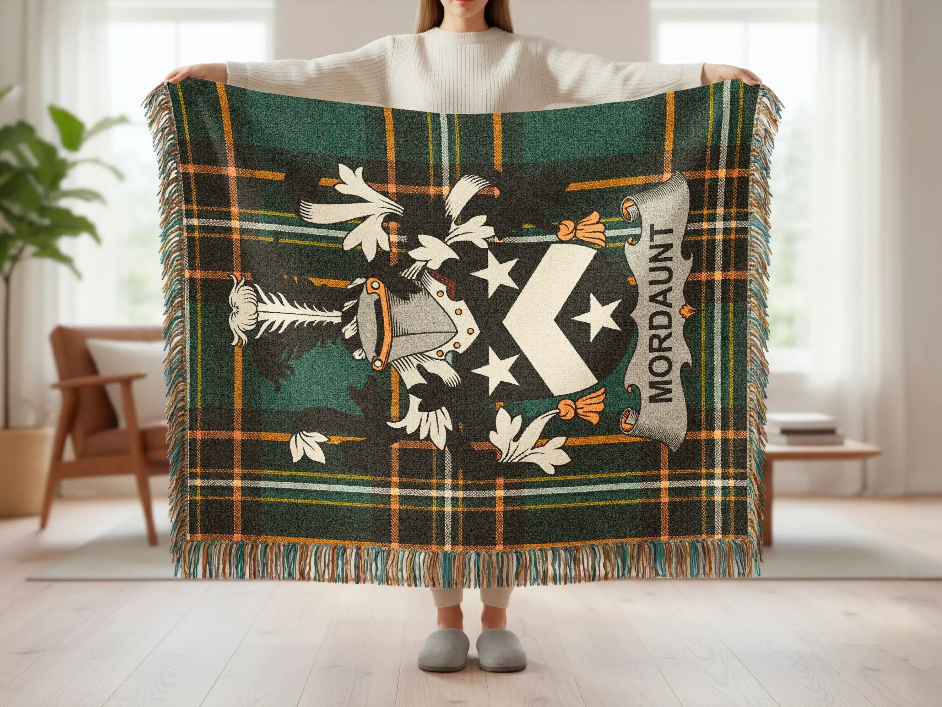 Tartan blanket with a coat of arms featuring the name "Mordaunt" held by a person.