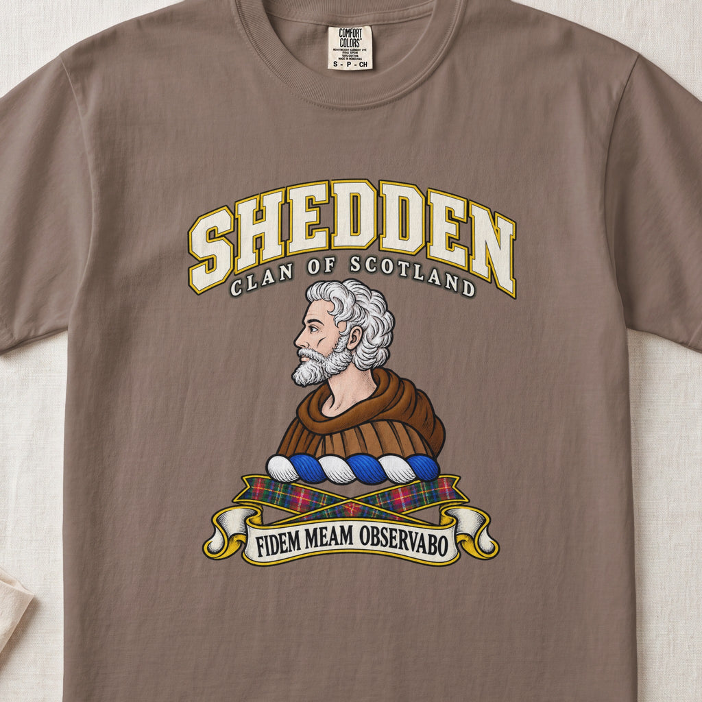 Shedden Scottish clan T-shirt in Espresso, front view with a gray-haired, bearded figure in a brown robe and motto design.
