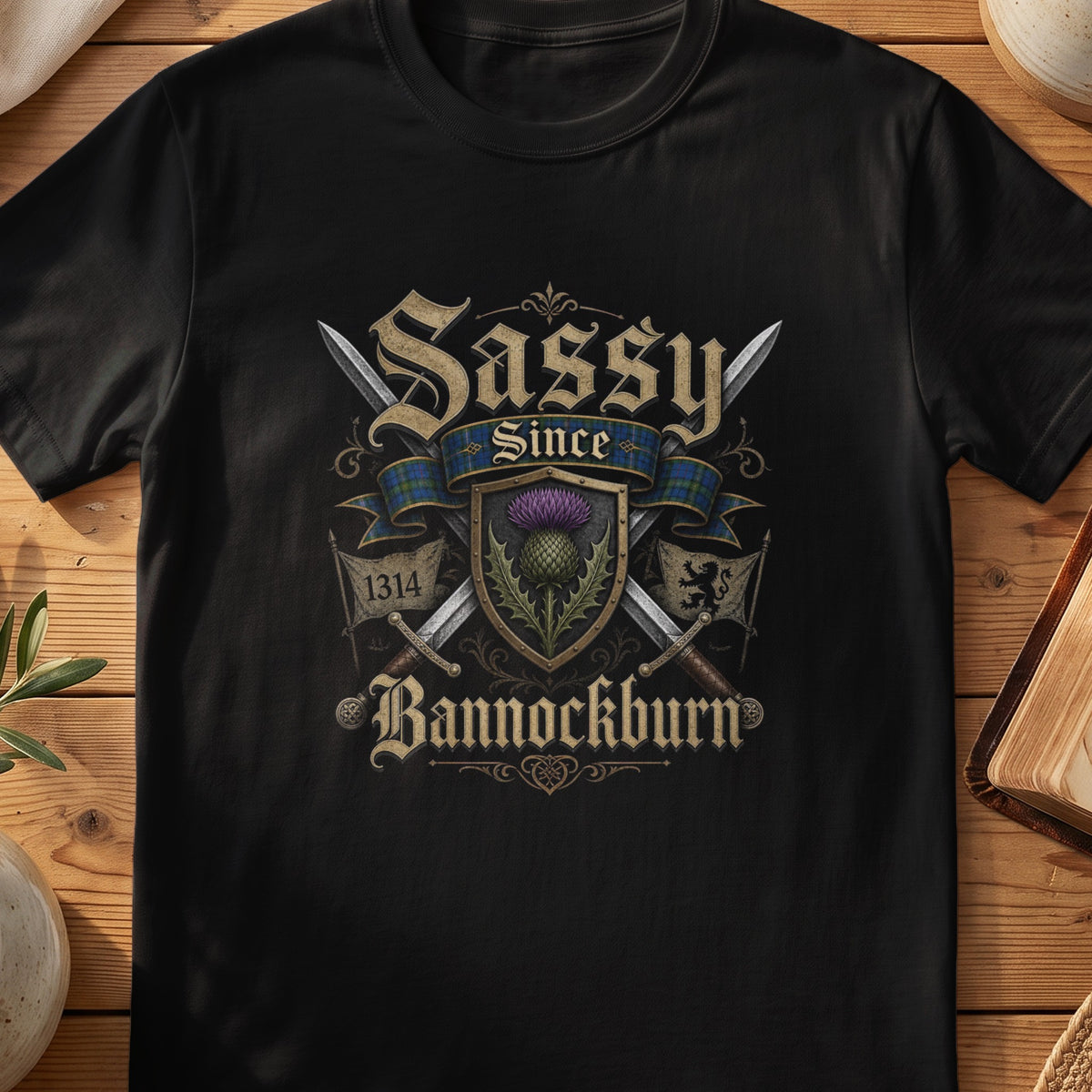 Black Gildan 64000 unisex T-shirt flatlay with Sassy Since Bannockburn 1314 Scottish graphic design