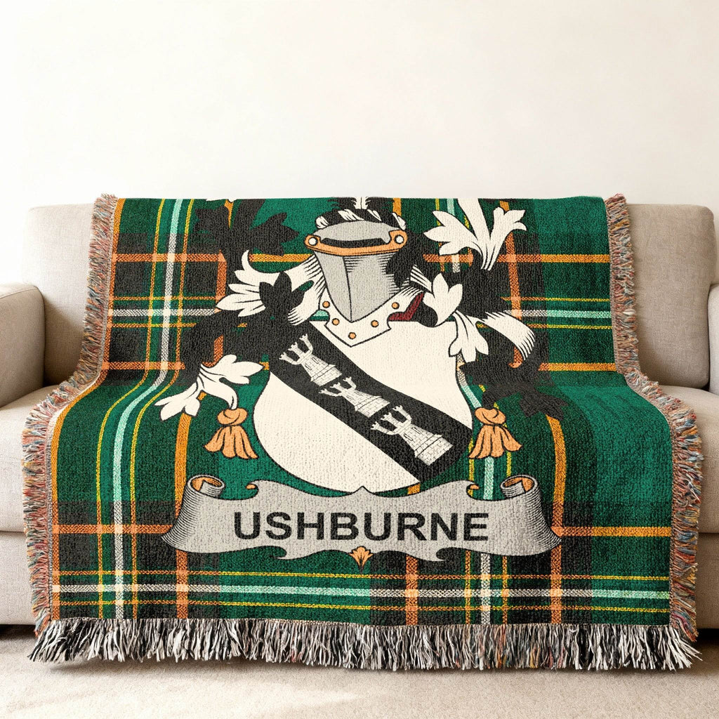 Green plaid throw blanket with Ushburne crest displayed.