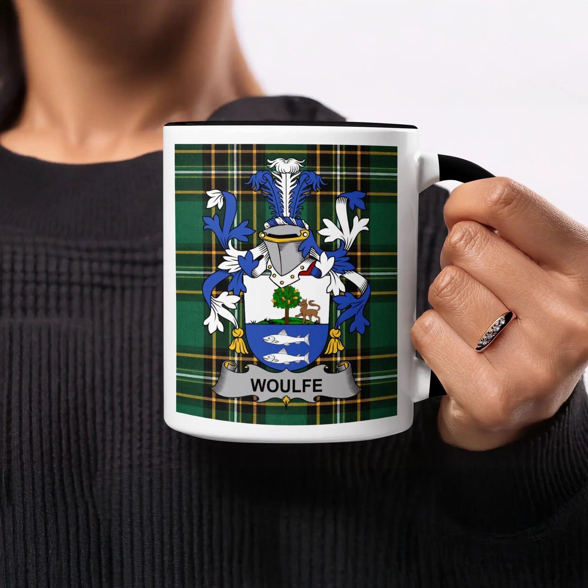 White mug with black rim featuring the Wolffe family crest on a green plaid background.