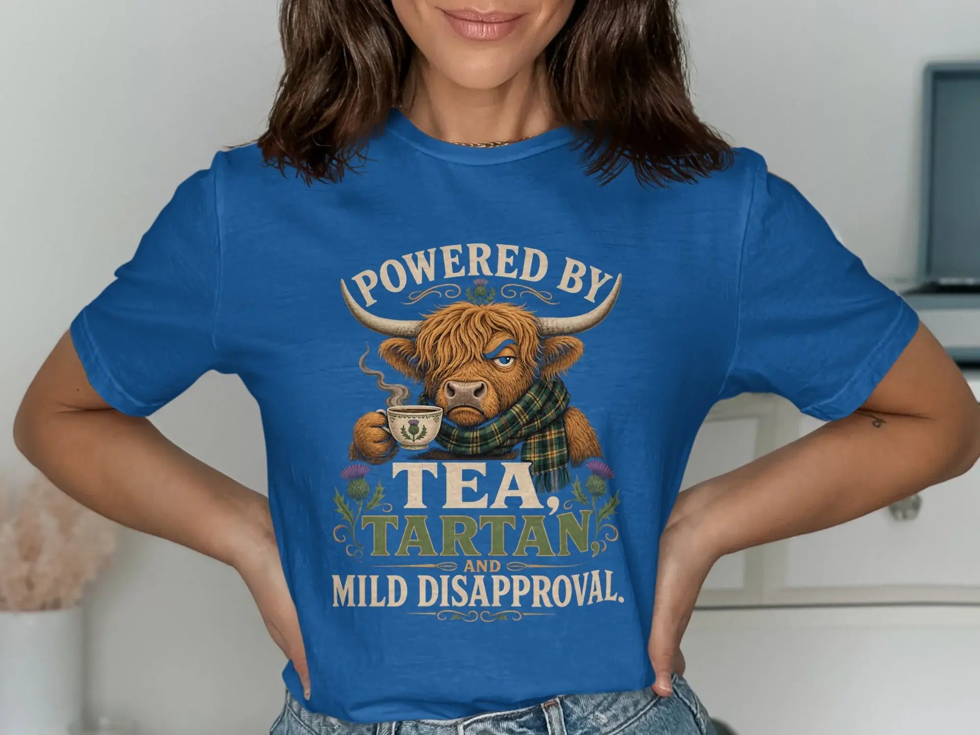 Blue t-shirt with Scottish Highland cow graphic and text.
