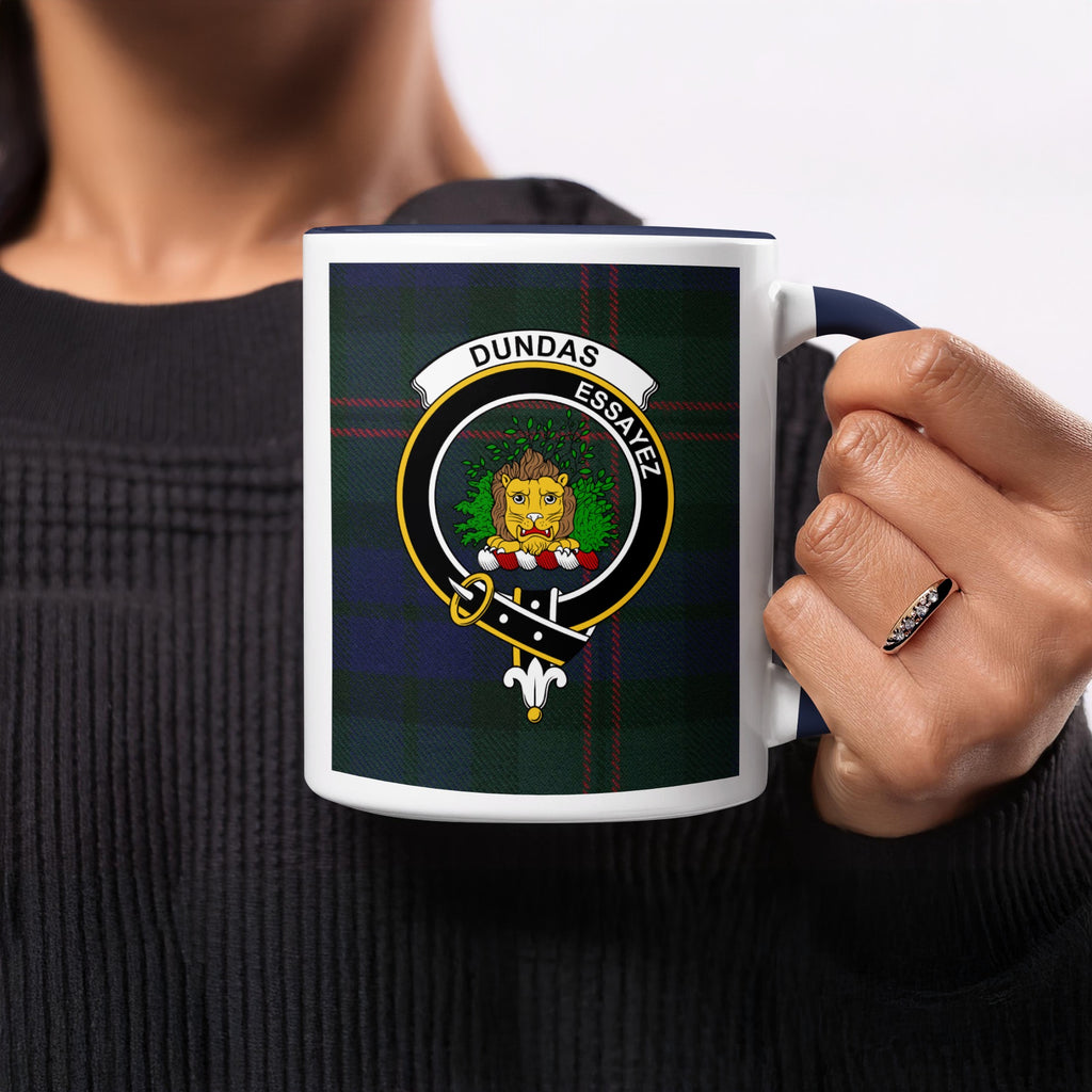 Close-up lifestyle view of Dundas Scottish family crest artwork on a navy 11 oz accent mug with a tartan background