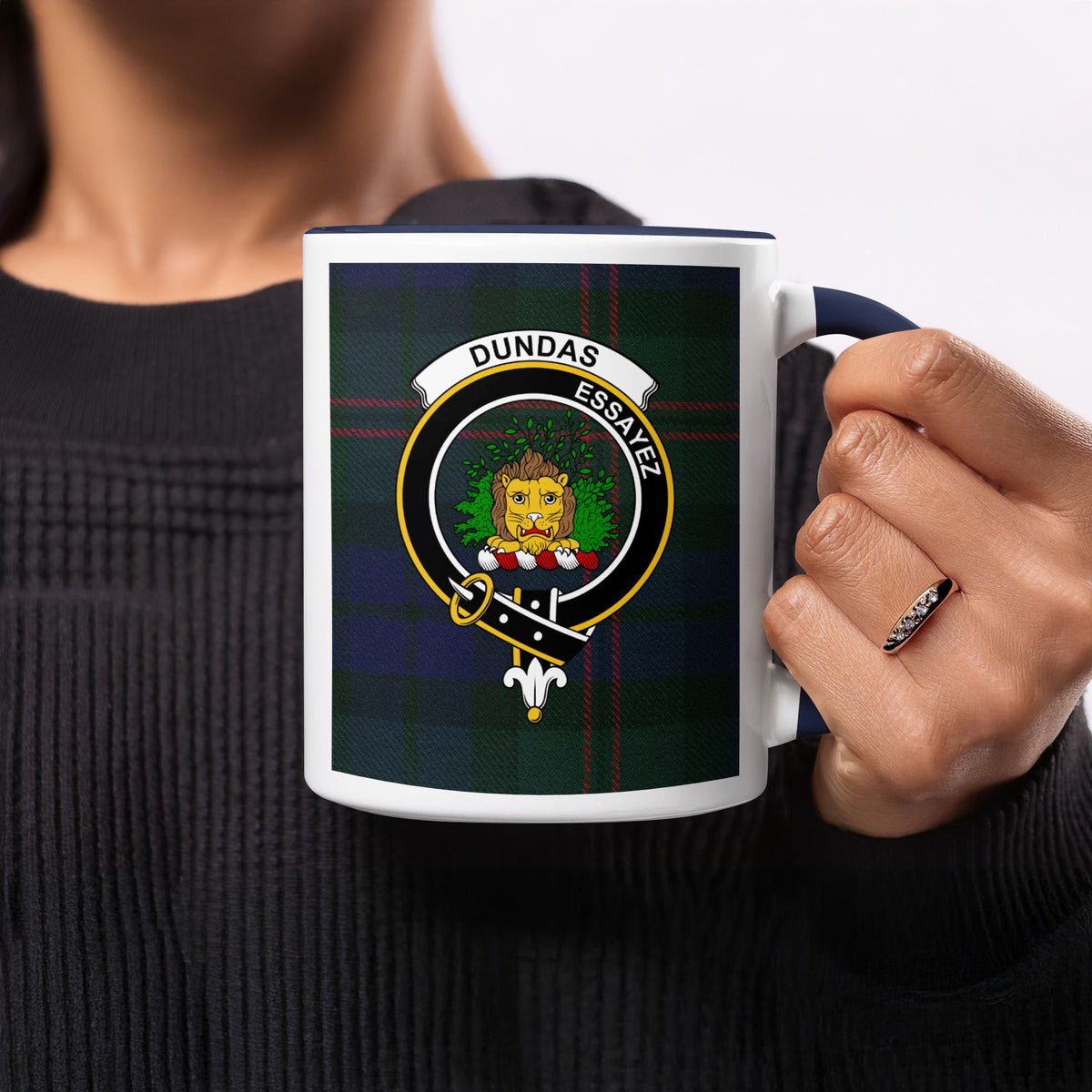 Close-up lifestyle view of Dundas Scottish family crest artwork on a navy 11 oz accent mug with a tartan background