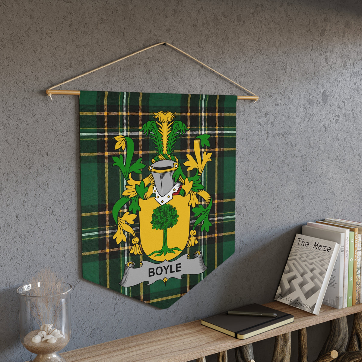 Boyle family crest on a green tartan pennant hanging on a textured wall.