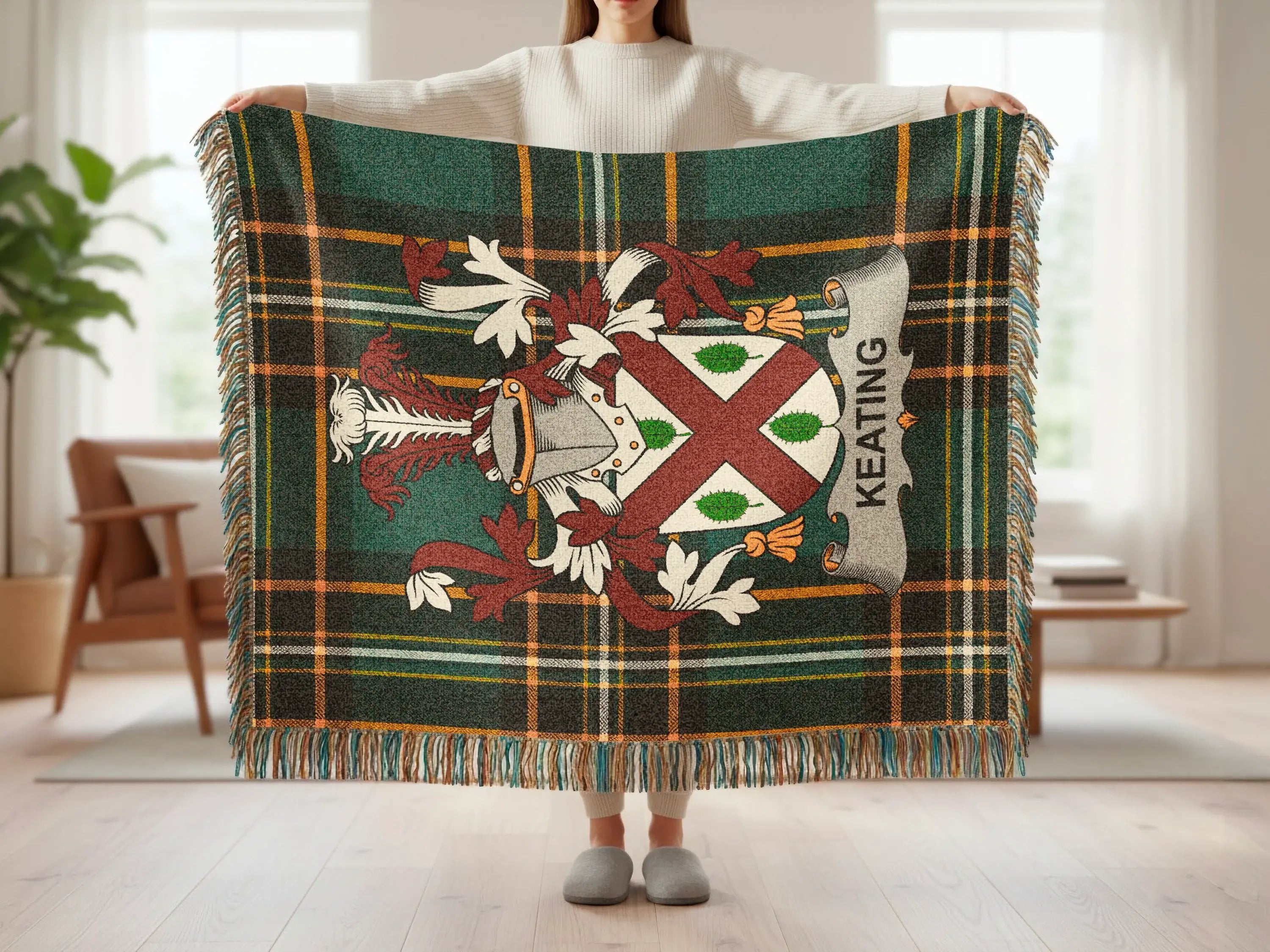 Keating tartan blanket with coat of arms and fringe, held by person.