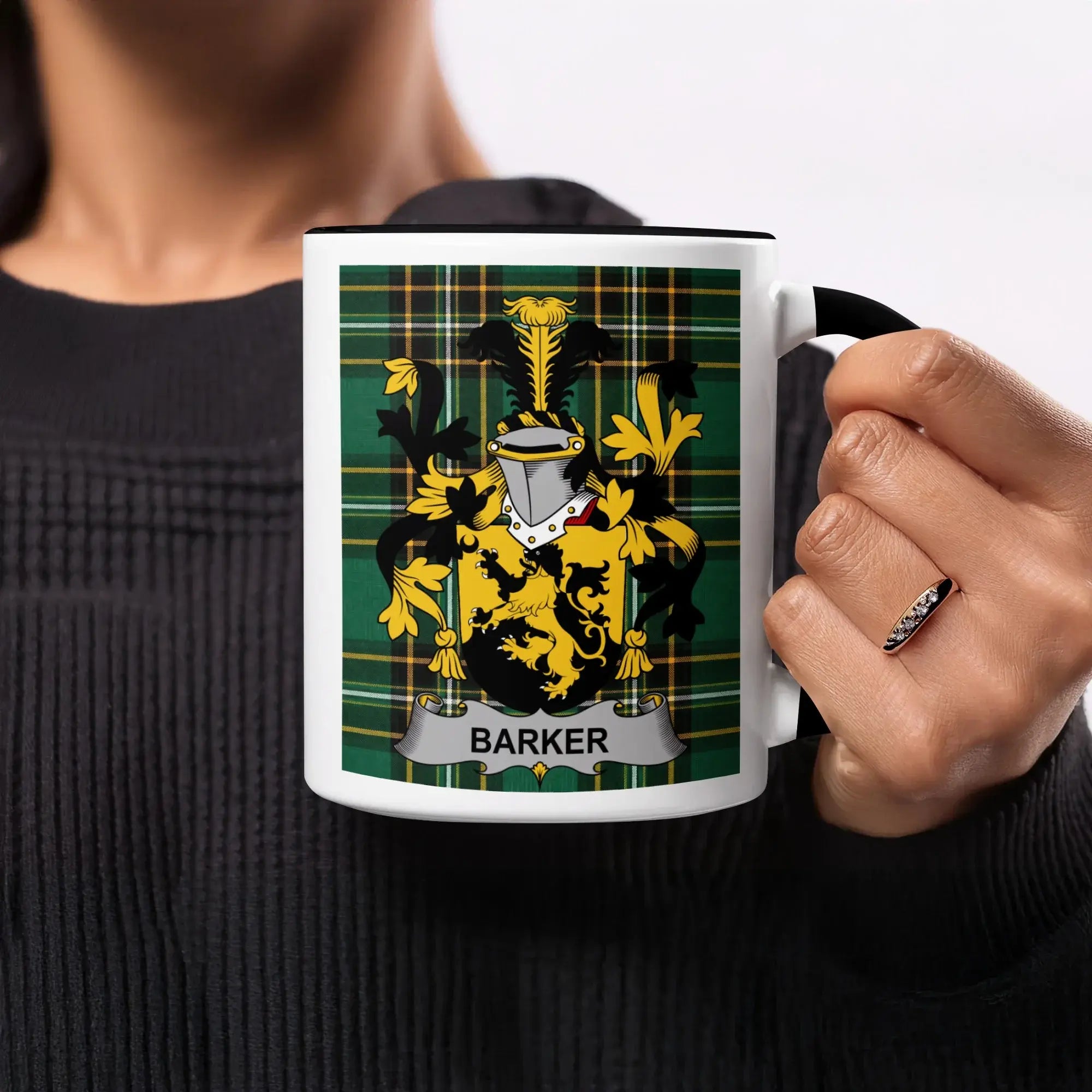 Black mug with black handle featuring a green tartan plaid design and the Barker family crest.