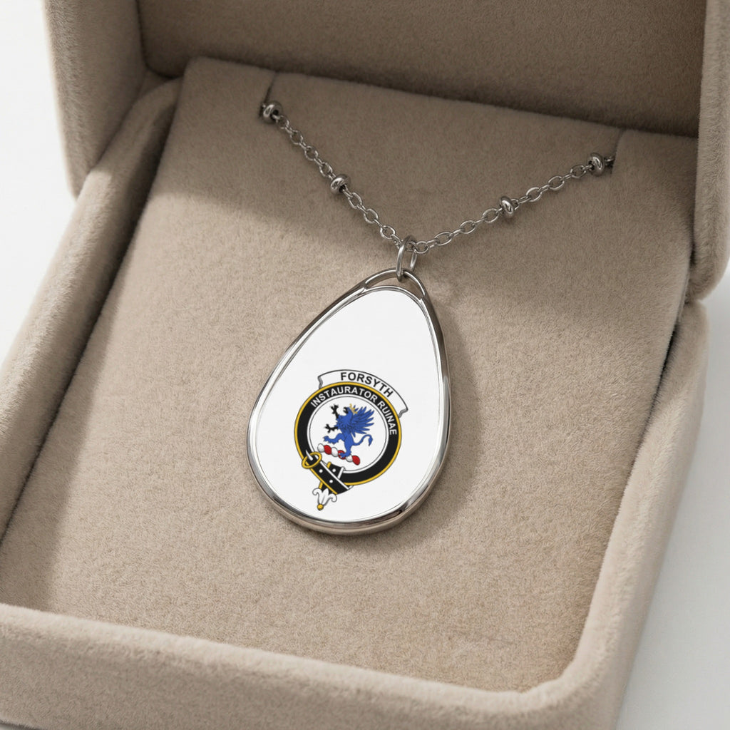Oval pendant necklace with Forsyth clan crest and motto, rests in a tan velvet jewelry box.