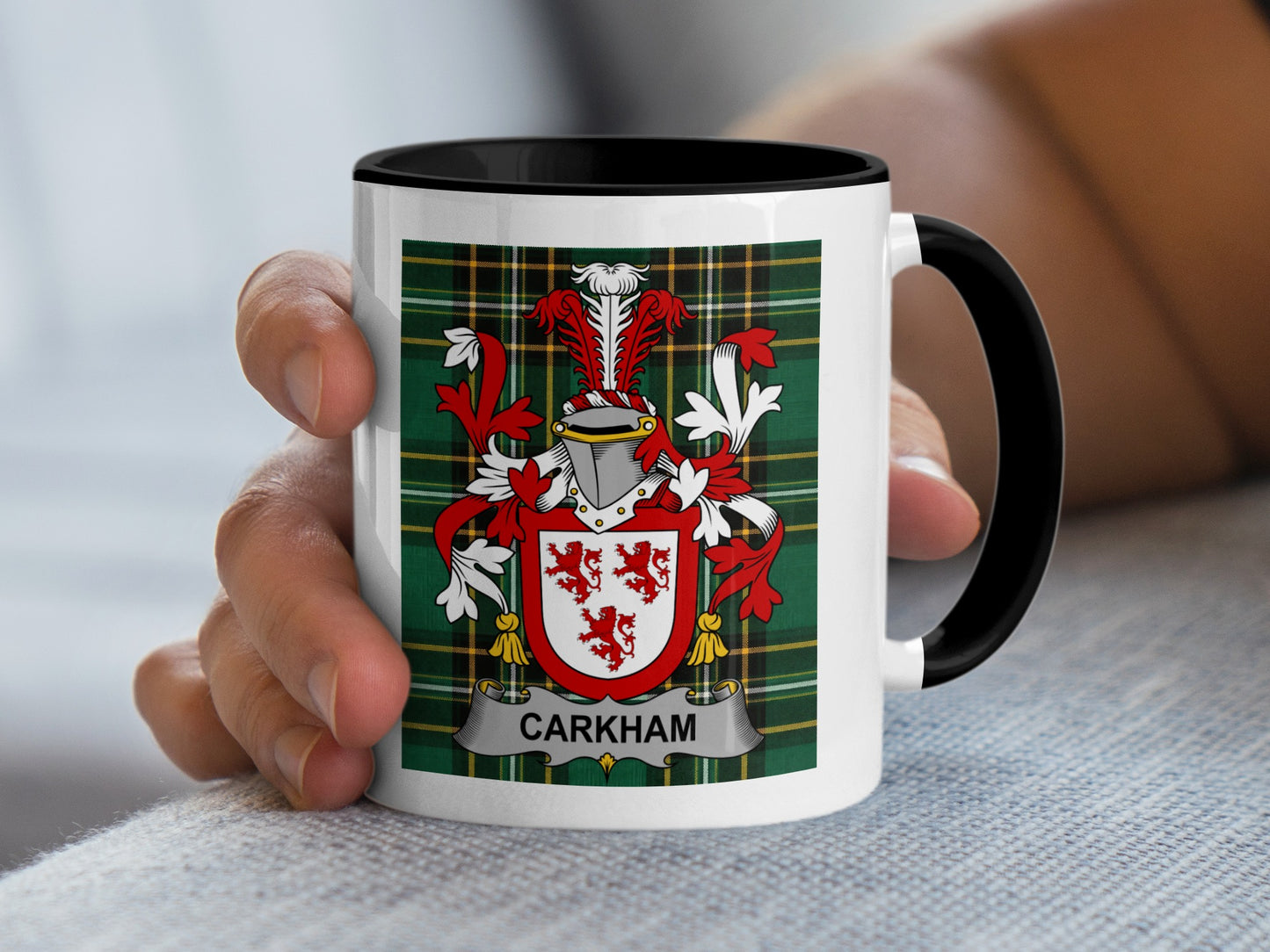 White mug with black rim, featuring a red and white family crest and tartan pattern.