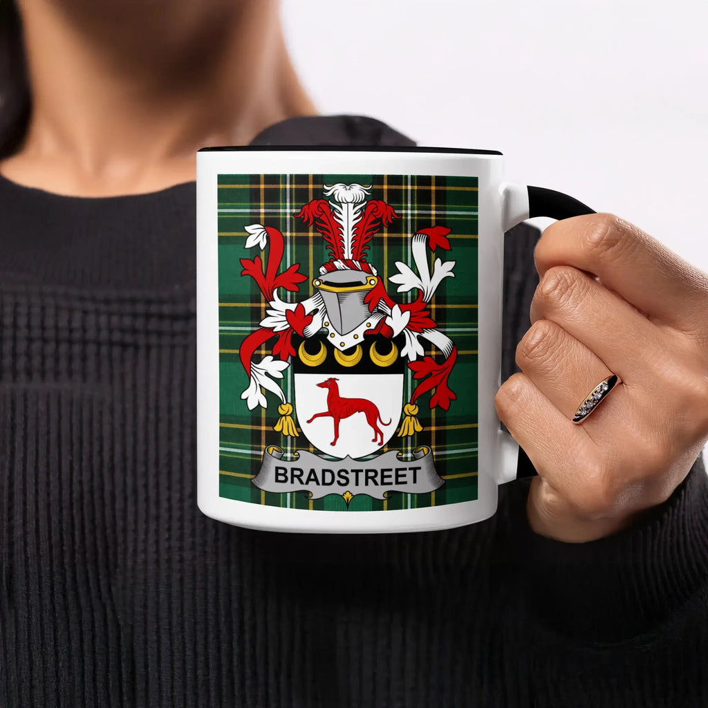 Bradstreet family crest on a white mug with a black handle and plaid background.