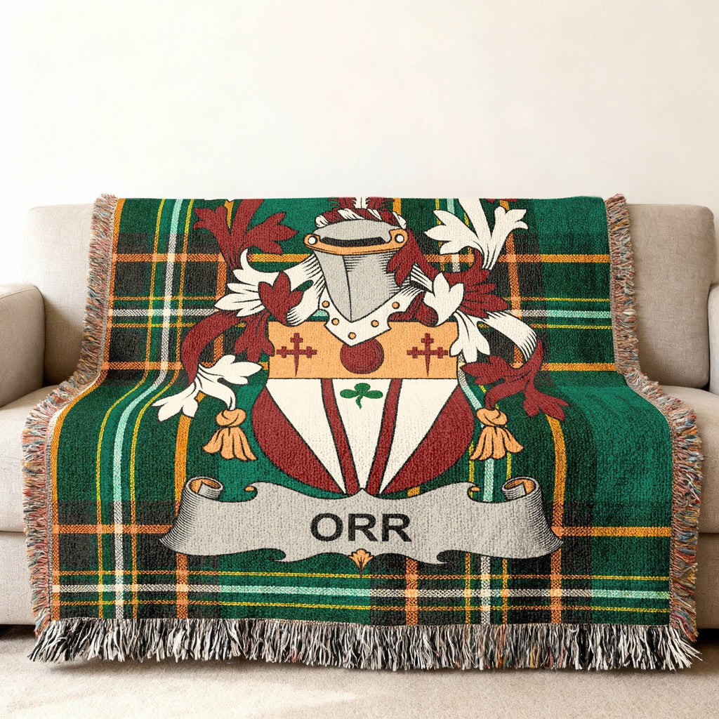 Green tartan blanket with the Orr family crest draped over a sofa.