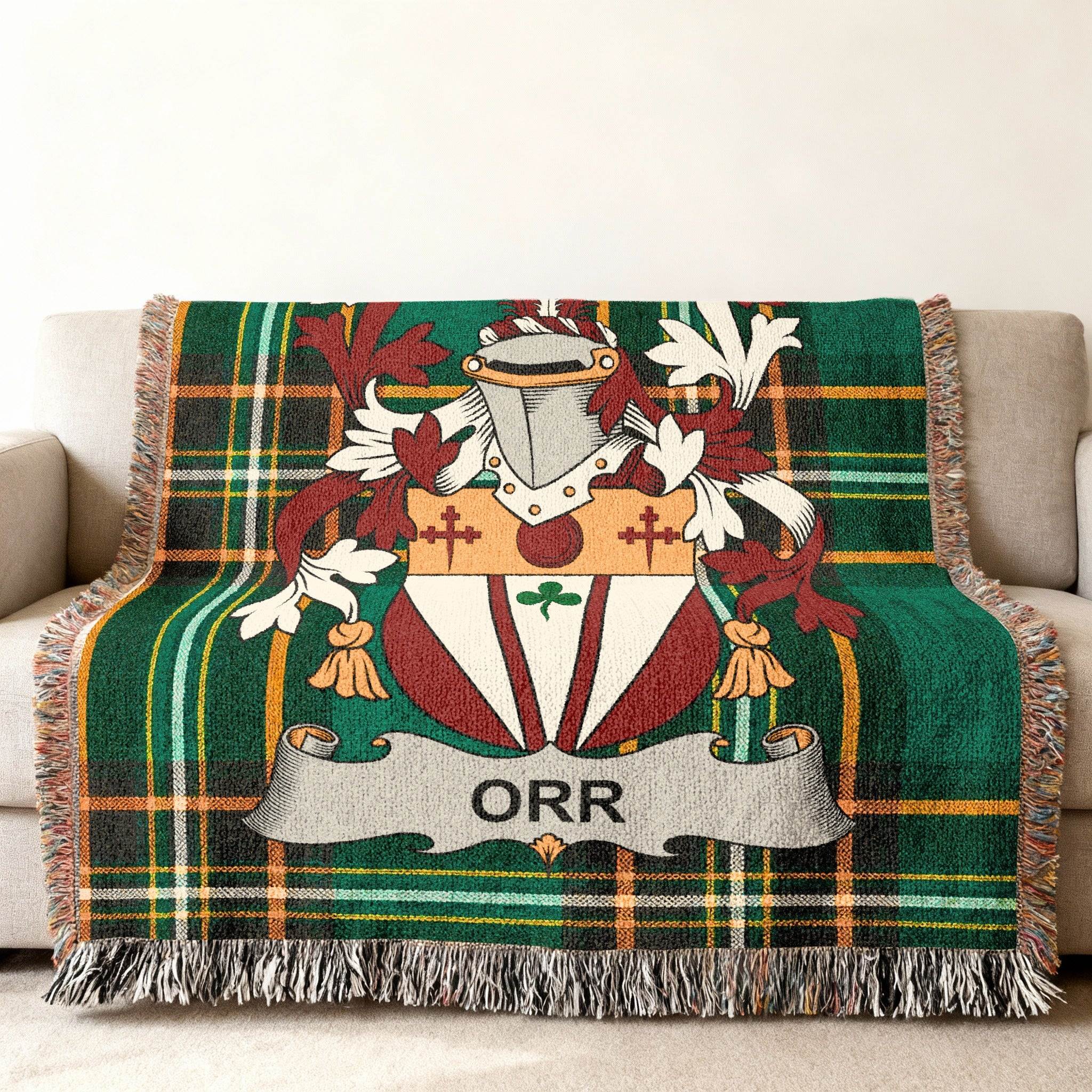 Green tartan blanket with the Orr family crest draped over a sofa.