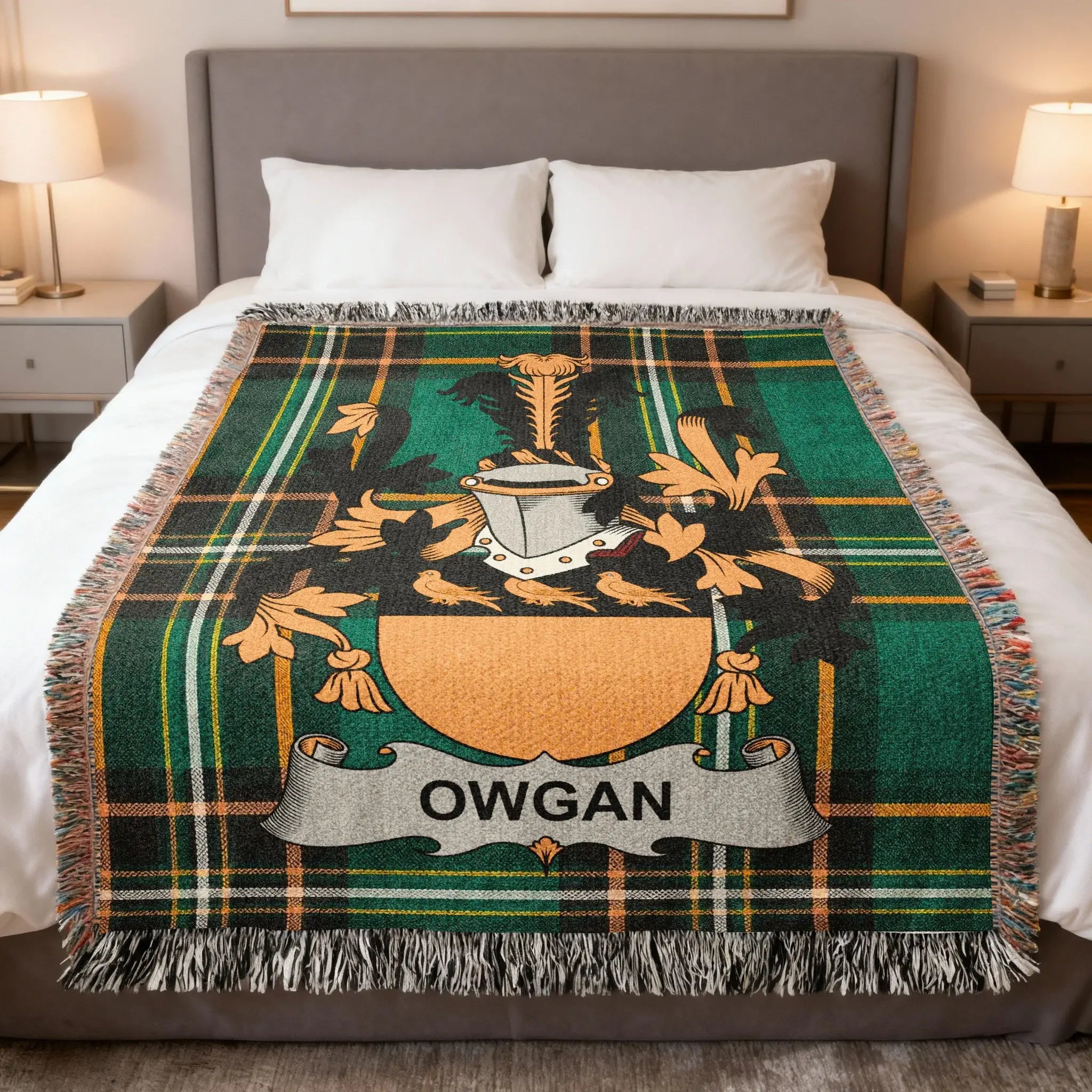 Tartan blanket with Owgan crest on a bed.