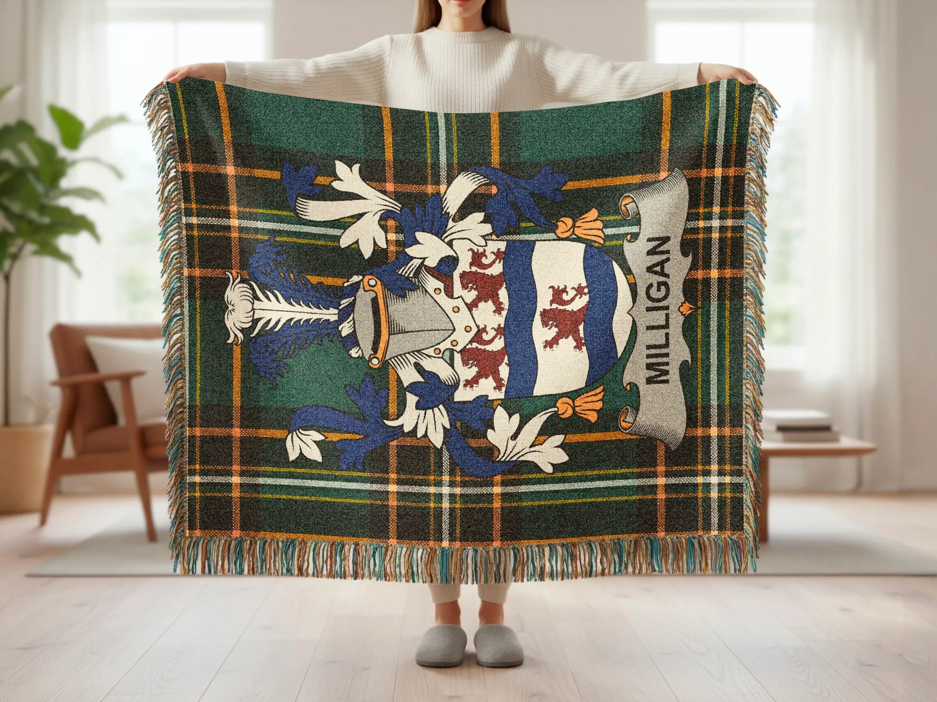 Tartan blanket with crest and "MILLIGAN" text held by a person.