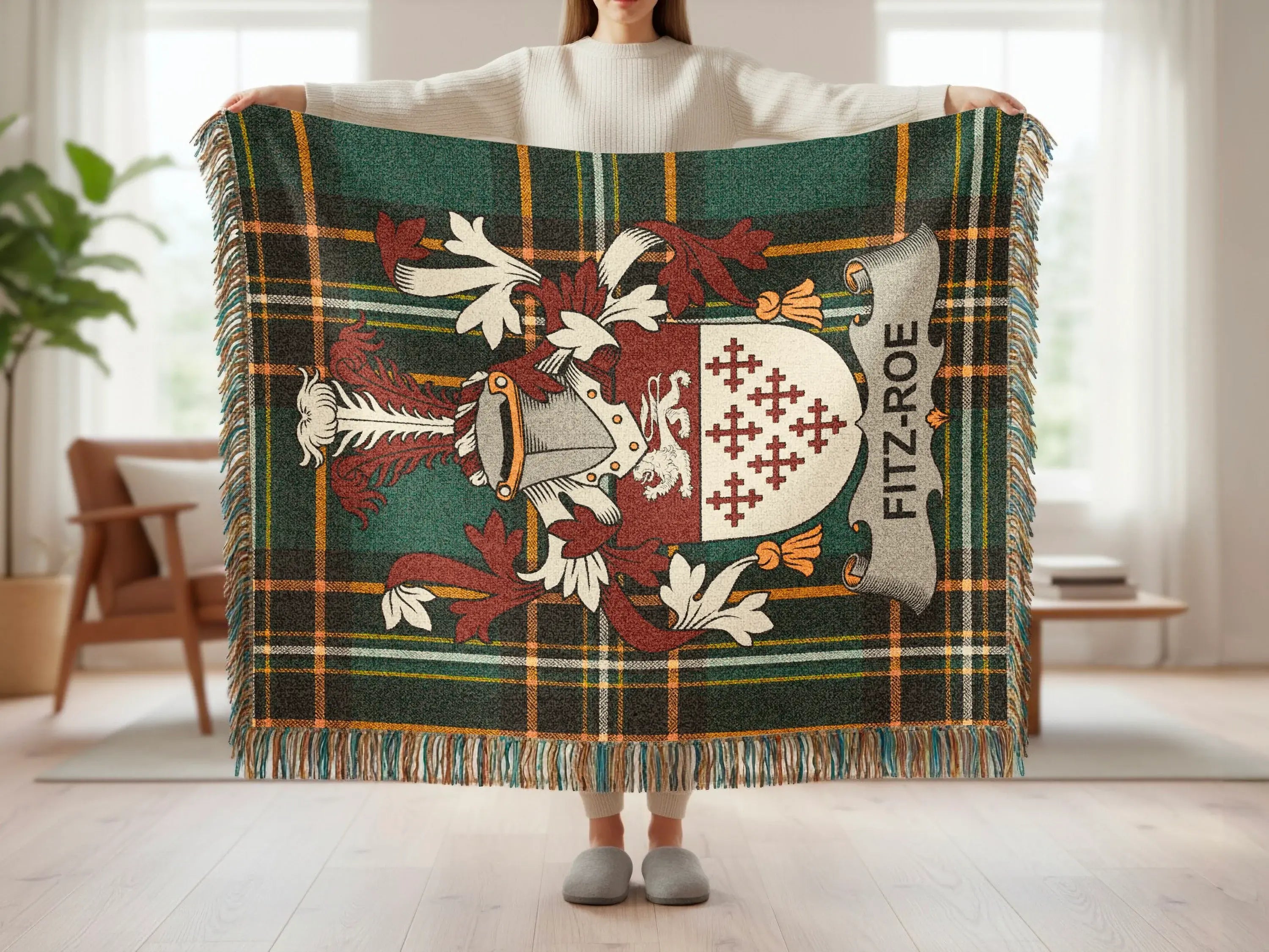 Tartan blanket with Fitz-Roe crest displayed by a person.
