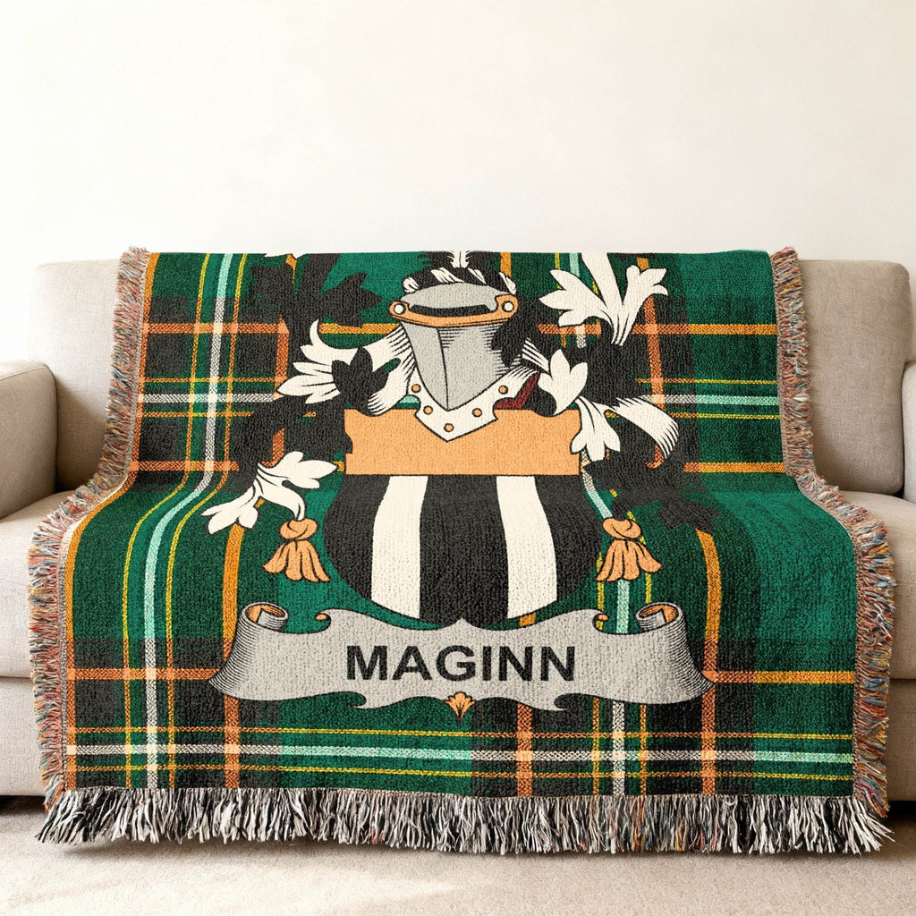 MAGINN tartan blanket with coat of arms on a sofa.