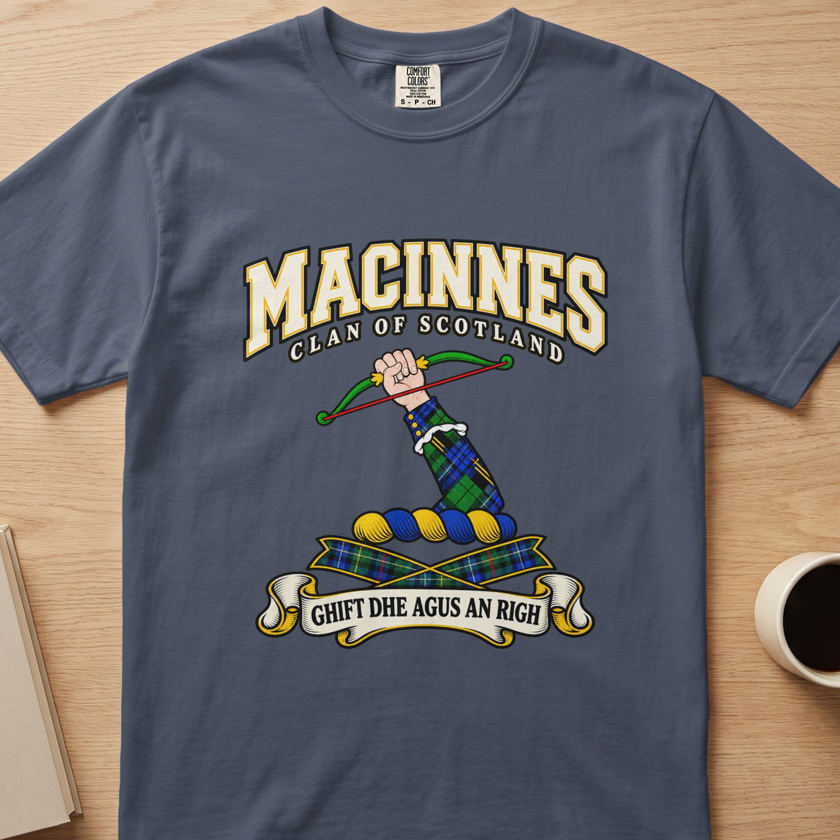 MacInnes clan crest with a bow and tartan ribbons on a slate blue Comfort Colors T-shirt, front view