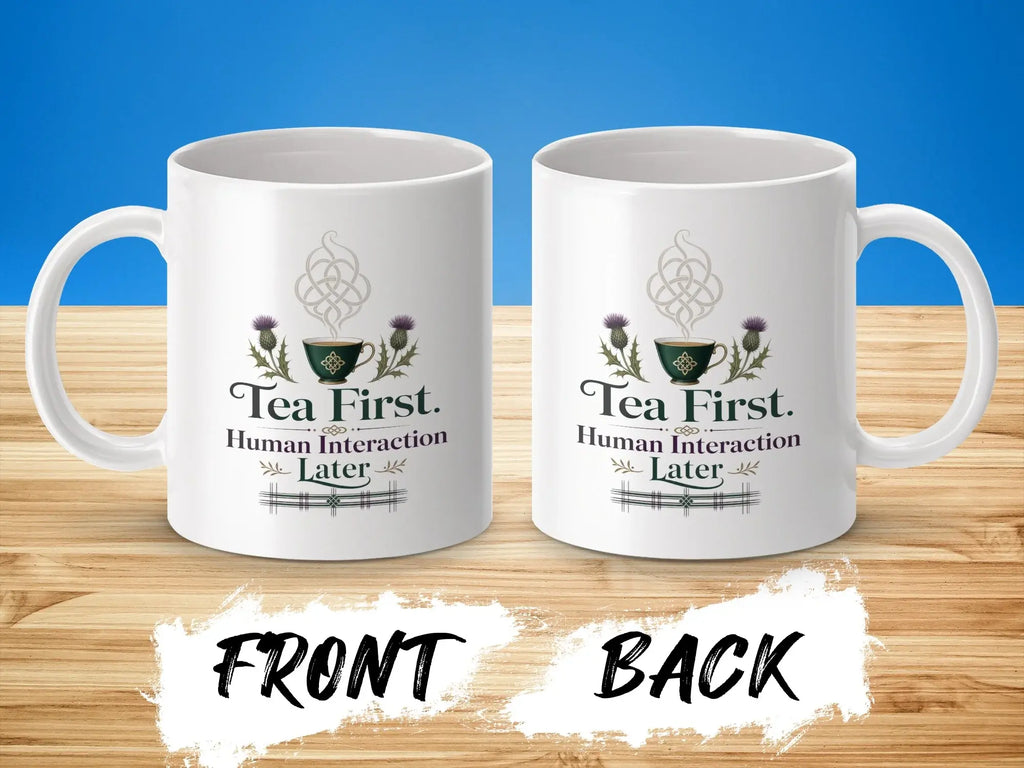 White mug with "Tea First. Human Interaction Later." text and thistle design.