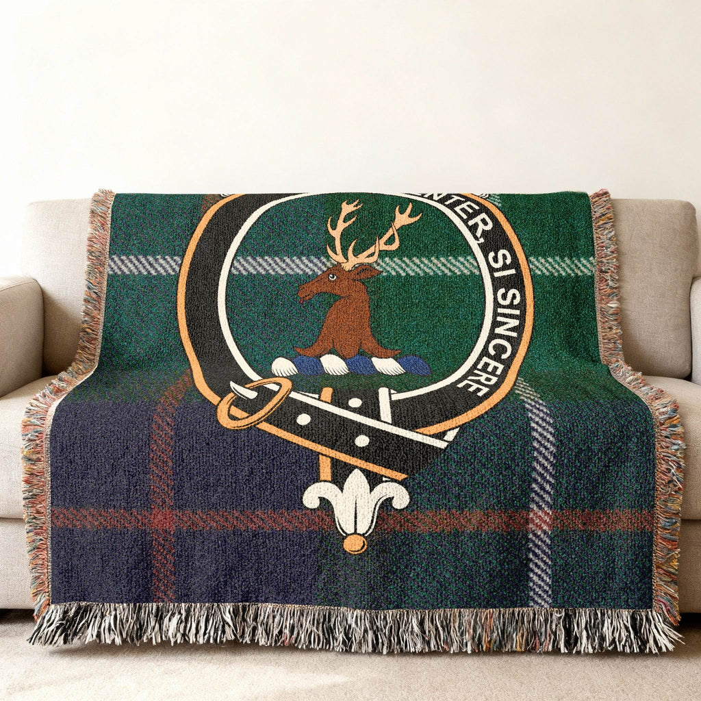 Davidson tartan woven blanket draped — white stag crest with green plaid, fringe edges