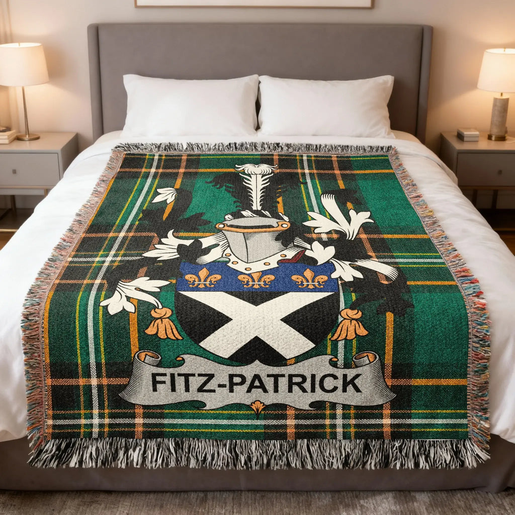 Tartan blanket with Fitz-Patrick family crest on a bed.