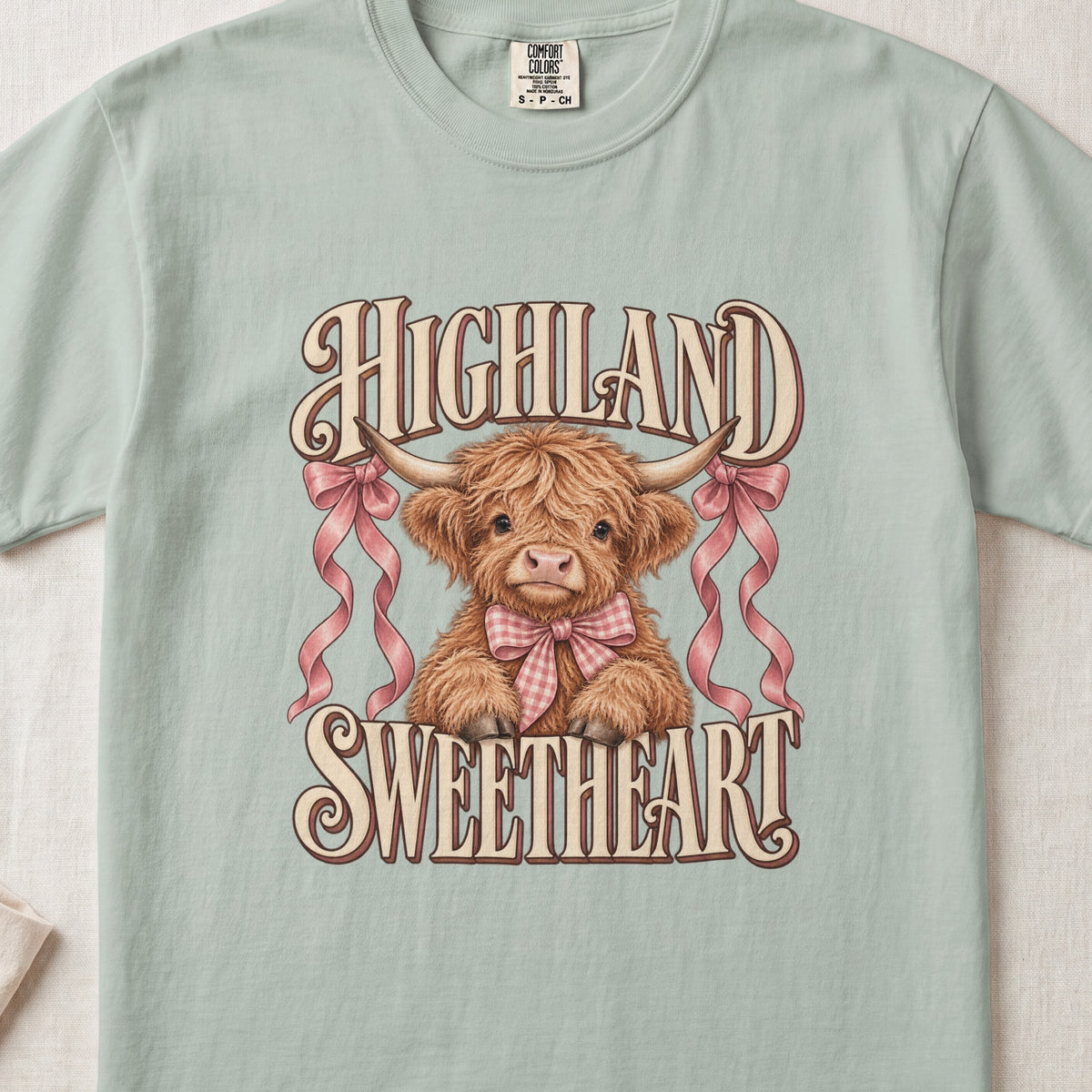 Highland Sweetheart Highland cow design on a Bay Comfort Colors 1717 T-shirt, flat lay
