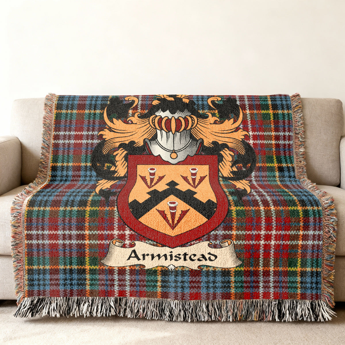 Armistead Scottish family shield woven blanket with Caledonia tartan background on a sofa