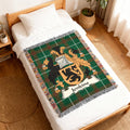 Woven blanket featuring a green plaid background with a family crest and the name "Jenkins".